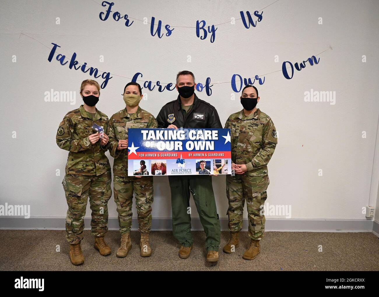 Robert Lankford, commandant du 62e Groupe des opérations de la Force aérienne des États-Unis, pose avec des agents de projet pour le Fonds d'assistance de la Force aérienne à la base conjointe Lewis-McChord, Washington, le 15 mars 2021. Lankford a été le premier donateur de la campagne de cette année. Banque D'Images