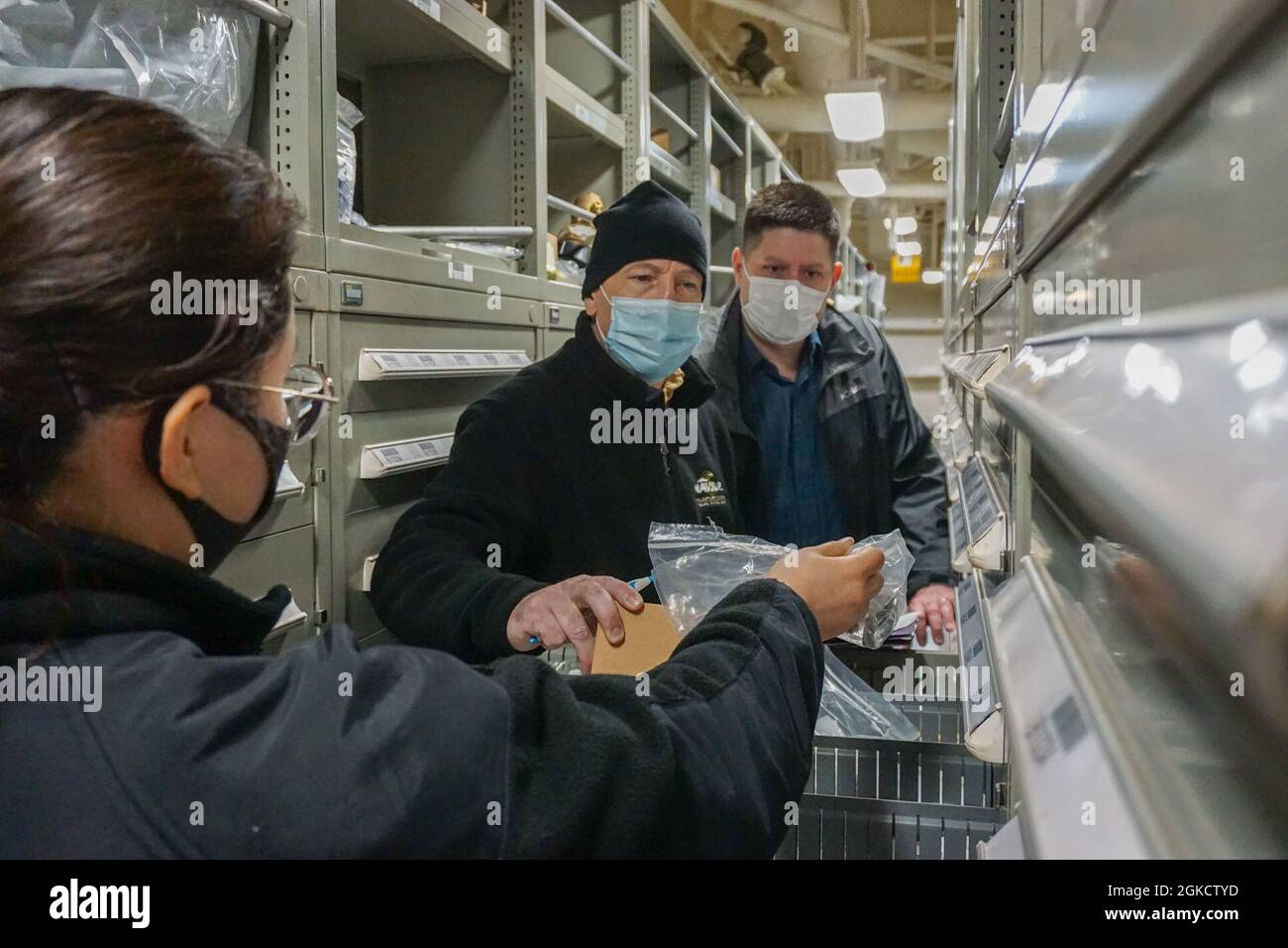 SASEBO, Japon (15 mars 2021) – Centre de logistique de la flotte NAVSUP Yokosuka Agent régional d'exactitude des stocks Frank Shaffer (au centre) et Directeur adjoint des services régionaux Steven Fritts (à droite) effectuent un inventaire d'un article dans un entrepôt à bord de l'USS America (LHA 6). Banque D'Images