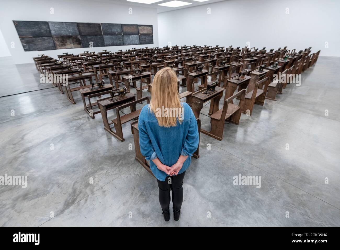 Londres, Royaume-Uni. 14 septembre 2021. Un membre du personnel voit Capital cadavres (2021) par Ibrahim Mahama, 100 machines à coudre en métal rouillé fixées aux bureaux d'école en bois. Aperçu de «Lazarus», la nouvelle exposition solo d’Ibrahim Mahama à la galerie White Cube de Bermondsey qui présente des installations à grande échelle, des sculptures et des collages. L'exposition est le résultat de plusieurs mois de recherche à Nkrumah Volini, dans le nord du Ghana, un silo en béton abandonné accueillant une grande colonie de chauves-souris qui a inspiré certains des travaux exposés. Le spectacle se déroulera du 15 septembre au 7 novembre 2021. Credit: Stephen Chung / Alamy Live News Banque D'Images Londres, Royaume-Uni. 14 septembre 2021. Un membre du personnel voit Capital cadavres (2021) par Ibrahim Mahama, 100 machines à coudre en métal rouillé fixées aux bureaux d'école en bois. Aperçu de «Lazarus», la nouvelle exposition solo d’Ibrahim Mahama à la galerie White Cube de Bermondsey qui présente des installations à grande échelle, des sculptures et des collages. L'exposition est le résultat de plusieurs mois de recherche à Nkrumah Volini, dans le nord du Ghana, un silo en béton abandonné accueillant une grande colonie de chauves-souris qui a inspiré certains des travaux exposés. Le spectacle se déroulera du 15 septembre au 7 novembre 2021. Credit: Stephen Chung / Alamy Live News Banque D'Images