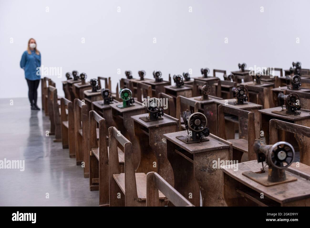 Londres, Royaume-Uni. 14 septembre 2021. Un membre du personnel voit Capital cadavres (2021) par Ibrahim Mahama, 100 machines à coudre en métal rouillé fixées aux bureaux d'école en bois. Aperçu de «Lazarus», la nouvelle exposition solo d’Ibrahim Mahama à la galerie White Cube de Bermondsey qui présente des installations à grande échelle, des sculptures et des collages. L'exposition est le résultat de plusieurs mois de recherche à Nkrumah Volini, dans le nord du Ghana, un silo en béton abandonné accueillant une grande colonie de chauves-souris qui a inspiré certains des travaux exposés. Le spectacle se déroulera du 15 septembre au 7 novembre 2021. Credit: Stephen Chung / Alamy Live News Banque D'Images Londres, Royaume-Uni. 14 septembre 2021. Un membre du personnel voit Capital cadavres (2021) par Ibrahim Mahama, 100 machines à coudre en métal rouillé fixées aux bureaux d'école en bois. Aperçu de «Lazarus», la nouvelle exposition solo d’Ibrahim Mahama à la galerie White Cube de Bermondsey qui présente des installations à grande échelle, des sculptures et des collages. L'exposition est le résultat de plusieurs mois de recherche à Nkrumah Volini, dans le nord du Ghana, un silo en béton abandonné accueillant une grande colonie de chauves-souris qui a inspiré certains des travaux exposés. Le spectacle se déroulera du 15 septembre au 7 novembre 2021. Credit: Stephen Chung / Alamy Live News Banque D'Images