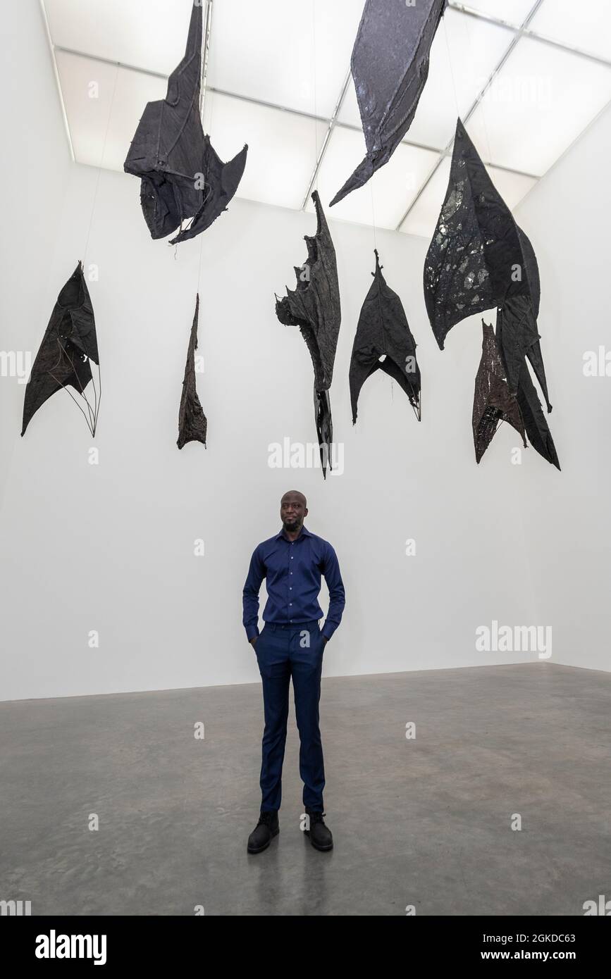 Londres, Royaume-Uni. 14 septembre 2021. Ibrahim Mahama avec son travail Lazarus, 2021. Aperçu de «Lazarus», la nouvelle exposition solo d’Ibrahim Mahama à la galerie White Cube de Bermondsey qui présente des installations à grande échelle, des sculptures et des collages. L'exposition est le résultat de plusieurs mois de recherche à Nkrumah Volini, dans le nord du Ghana, un silo en béton abandonné accueillant une grande colonie de chauves-souris qui a inspiré certains des travaux exposés. Le spectacle se déroulera du 15 septembre au 7 novembre 2021. Credit: Stephen Chung / Alamy Live News Banque D'Images Londres, Royaume-Uni. 14 septembre 2021. Ibrahim Mahama avec son travail Lazarus, 2021. Aperçu de «Lazarus», la nouvelle exposition solo d’Ibrahim Mahama à la galerie White Cube de Bermondsey qui présente des installations à grande échelle, des sculptures et des collages. L'exposition est le résultat de plusieurs mois de recherche à Nkrumah Volini, dans le nord du Ghana, un silo en béton abandonné accueillant une grande colonie de chauves-souris qui a inspiré certains des travaux exposés. Le spectacle se déroulera du 15 septembre au 7 novembre 2021. Credit: Stephen Chung / Alamy Live News Banque D'Images