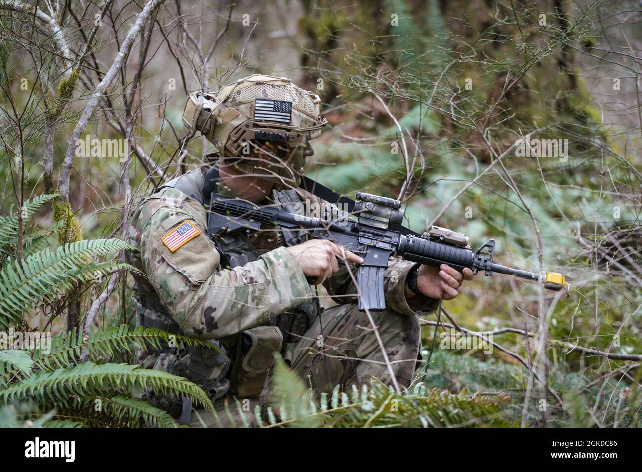 Un soldat de la Garde nationale de l'Armée de Washington affecté au 1er Bataillon, 161e Régiment d'infanterie, 81e équipe de combat de la Brigade Stryker réagit au contact lors d'une patrouille dans le cours des chefs de lumière à la base interarmées Lewis-McChord, le 19 mars 2021. Le cours Light leaders forme les soldats à devenir des chefs d'infanterie plus compétents en développant les principes fondamentaux des opérations de l'équipe et en renforçant leurs capacités de leadership. Au cours de l'entraînement, les chefs dirigent leurs équipes dans les mouvements tactiques d'infanterie, la navigation terrestre, la planification tactique, les exercices de combat, les patrouilles, et des exercices d'entraînement sur le terrain. Banque D'Images