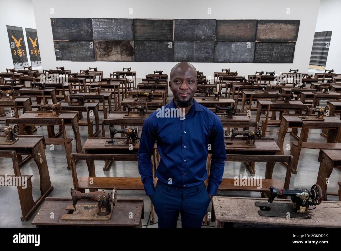 Londres, Royaume-Uni. 14 septembre 2021. Ibrahim Mahama avec son travail Capital cadavres (2021), 100 machines à coudre en métal rouillé fixées aux bureaux d'école en bois. Aperçu de «Lazarus», la nouvelle exposition solo d’Ibrahim Mahama à la galerie White Cube de Bermondsey qui présente des installations à grande échelle, des sculptures et des collages. L'exposition est le résultat de plusieurs mois de recherche à Nkrumah Volini, dans le nord du Ghana, un silo en béton abandonné accueillant une grande colonie de chauves-souris qui a inspiré certains des travaux exposés. Le spectacle se déroulera du 15 septembre au 7 novembre 2021. Credit: Stephen Chung / Alamy Live News Banque D'Images Londres, Royaume-Uni. 14 septembre 2021. Ibrahim Mahama avec son travail Capital cadavres (2021), 100 machines à coudre en métal rouillé fixées aux bureaux d'école en bois. Aperçu de «Lazarus», la nouvelle exposition solo d’Ibrahim Mahama à la galerie White Cube de Bermondsey qui présente des installations à grande échelle, des sculptures et des collages. L'exposition est le résultat de plusieurs mois de recherche à Nkrumah Volini, dans le nord du Ghana, un silo en béton abandonné accueillant une grande colonie de chauves-souris qui a inspiré certains des travaux exposés. Le spectacle se déroulera du 15 septembre au 7 novembre 2021. Credit: Stephen Chung / Alamy Live News Banque D'Images