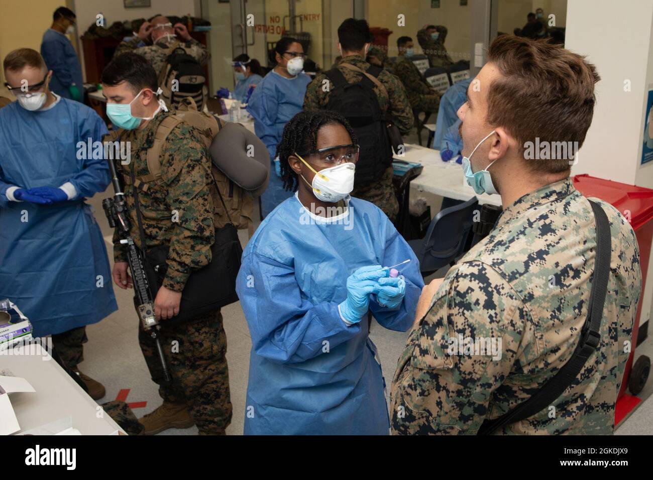 U.S. Navy Hospitalman Janeyah Berry, centre, un technicien médical d'urgence avec Marine Rotational Force - Darwin, se prépare à administrer un test COVID-19 à une marine américaine avec MRF-D, à la base aérienne royale australienne, Darwin, NT, Australie, mars 22, 2021. Les marins et les marins avec MRF-D sont tenus de mener des procédures d'atténuation strictes COVID-19 avant leur arrivée à Darwin, conformément aux autorités sanitaires du territoire du Nord. Tous les membres du service doivent fournir trois tests d'écouvillonnage négatifs COVID-19 documentés tout au long de leur voyage et avant d'être libérés d'une période de quarantaine de 14 jours Banque D'Images