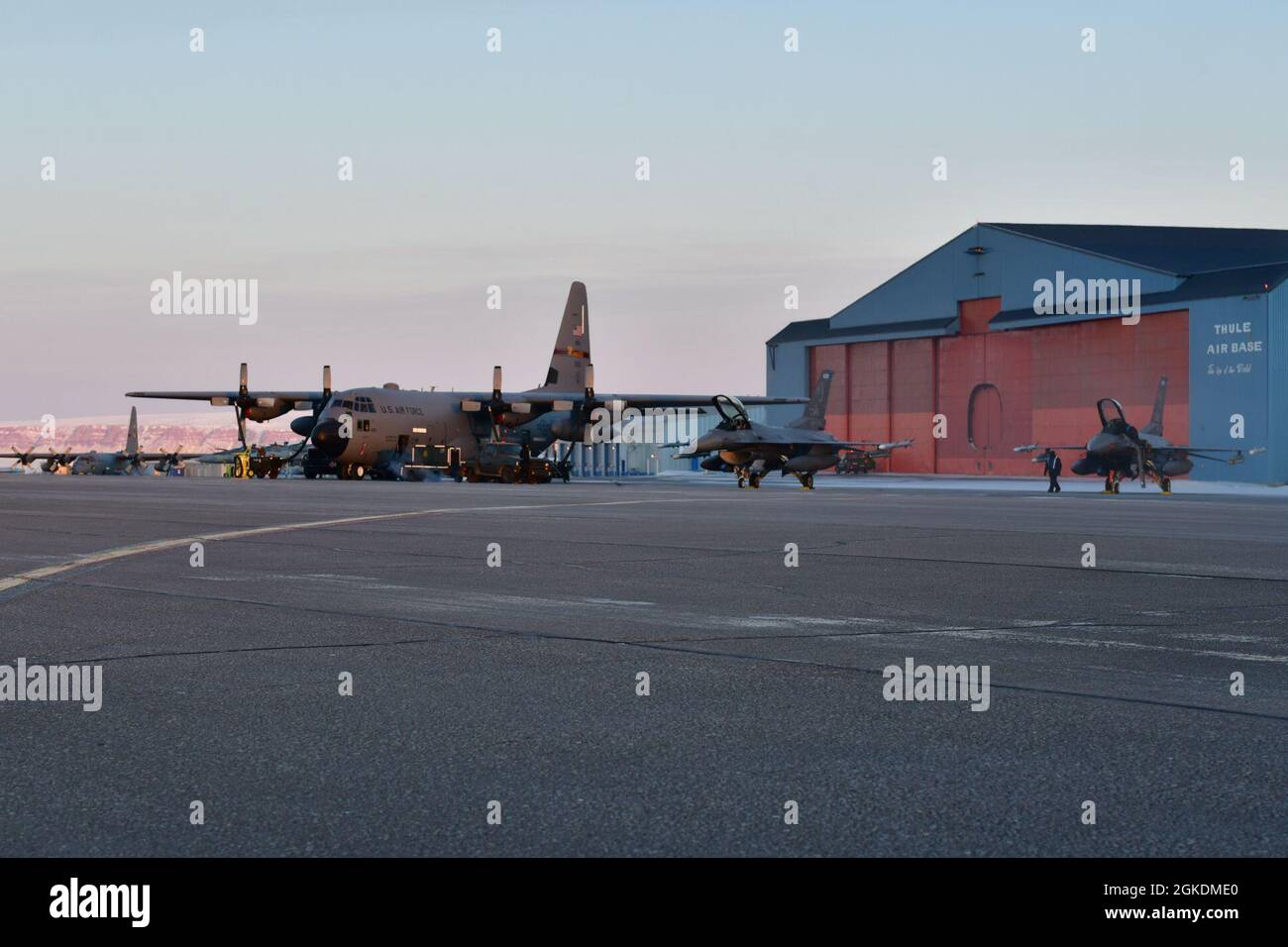 Un avion de la Garde nationale aérienne du Minnesota C-130 Hercules (à gauche) se trouve près de deux F-16 Fighting Falcons (à droite) à la base aérienne de Thule, au Groenland, lors de l’exercice de défense aérienne arctique du Commandement de la défense aérospatiale de l’Amérique du Nord, Aralgam Dart 21-02, le 23 mars 2021. L'exercice se tiendra à partir de mars 20-26 et s'étendra de la mer de Beaufort à Thule, au Groenland, et s'étendra vers le sud, le long de l'Atlantique est, jusqu'à la côte américaine du Maine. Amalgame Dart 21-2 offre au NORAD l'occasion de perfectionner ses compétences en matière de défense de la patrie à mesure que les forces canadiennes, américaines et de l'OTAN opèrent ensemble dans l'Arctique. Un commandement binational canadien et américain, NORA Banque D'Images