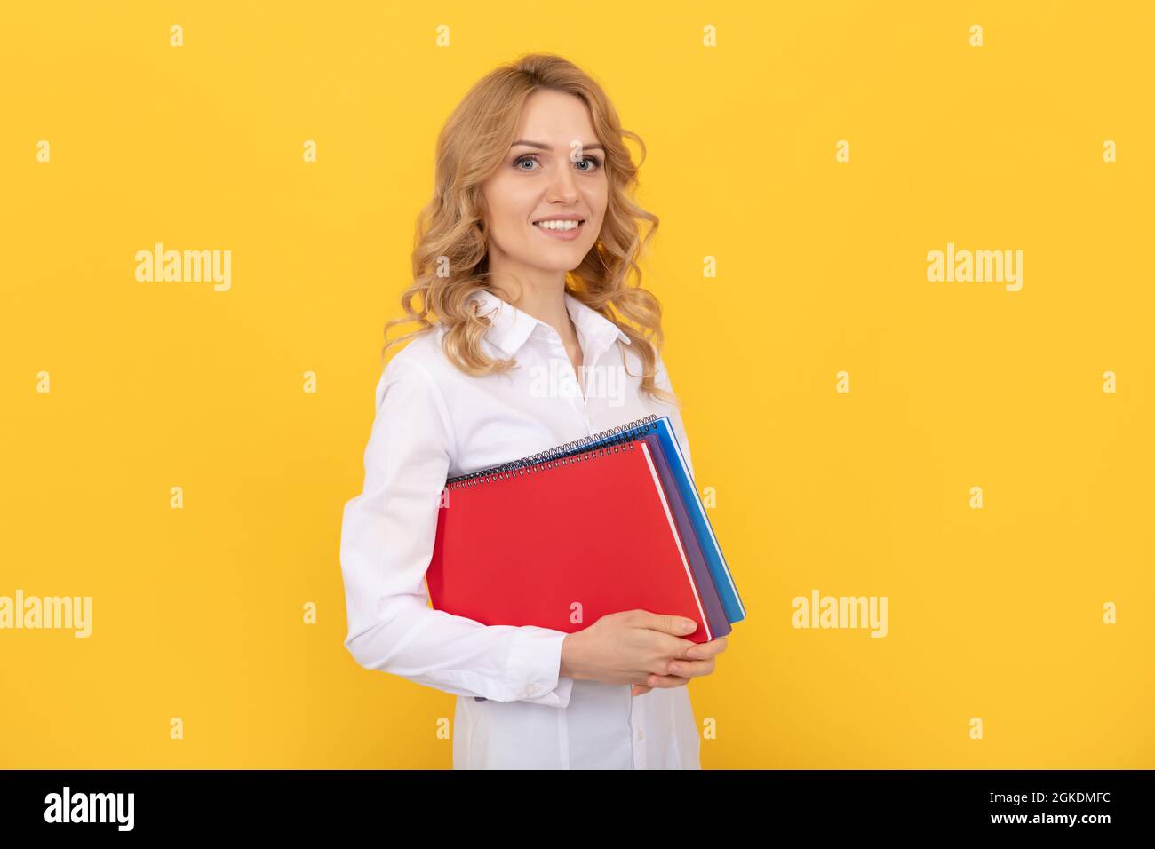 bonne blonde femme d'affaires dans chemise blanche tenir bloc-notes ou bloc-notes, enseignant d'école Banque D'Images