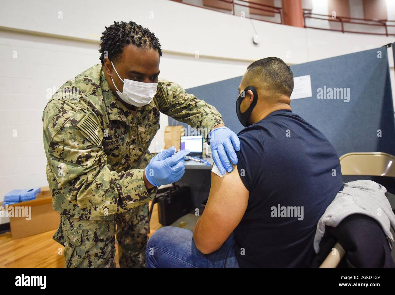 Queens, NY (24 mars 2021) - Un hôpital Corpsman administre la vaccination COVID-19 à un membre de la communauté en Jamaïque, Queens, New York cent trente-neuf marins de Navy Medicine East aident le personnel médical et fournissent un soutien logistique au Centre de vaccination communautaire dirigé par l'Agence fédérale de gestion des urgences du York College. Le ministère de la Défense a fourni 278 membres du personnel médical et de soutien de la Marine et de la Force aérienne pour appuyer deux CVC à New York dans le cadre de l'intervention pangouvernementale face à la pandémie COVID-19. Banque D'Images