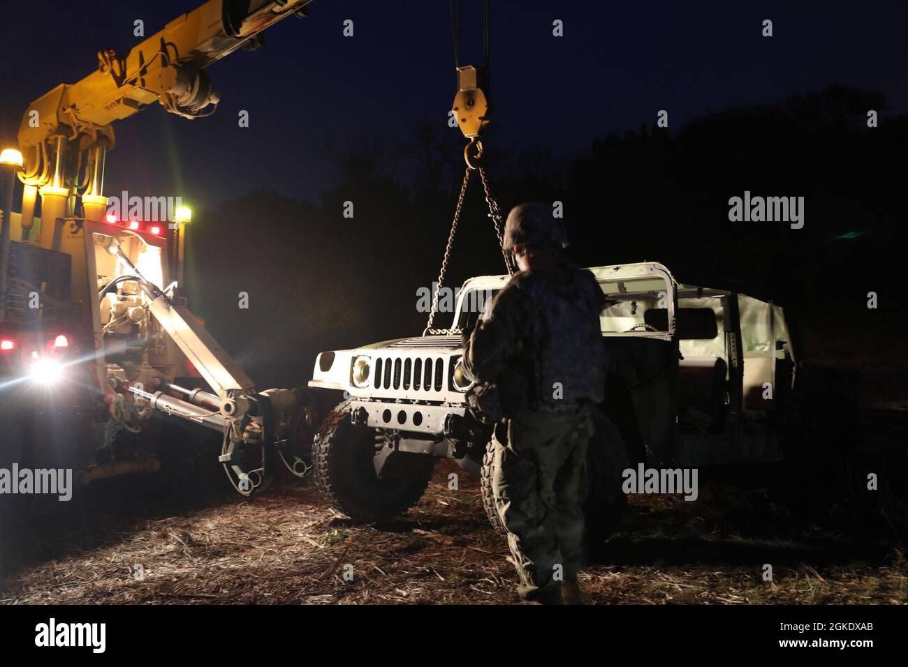 Les soldats de la 163e Brigade de renseignement militaire préparent l'épave à être accrochée à un véhicule en panne, le 24 mars 2021, fort Hood, Texas. Les opérations de dépannage du véhicule sont effectuées de nuit et de jour. Banque D'Images