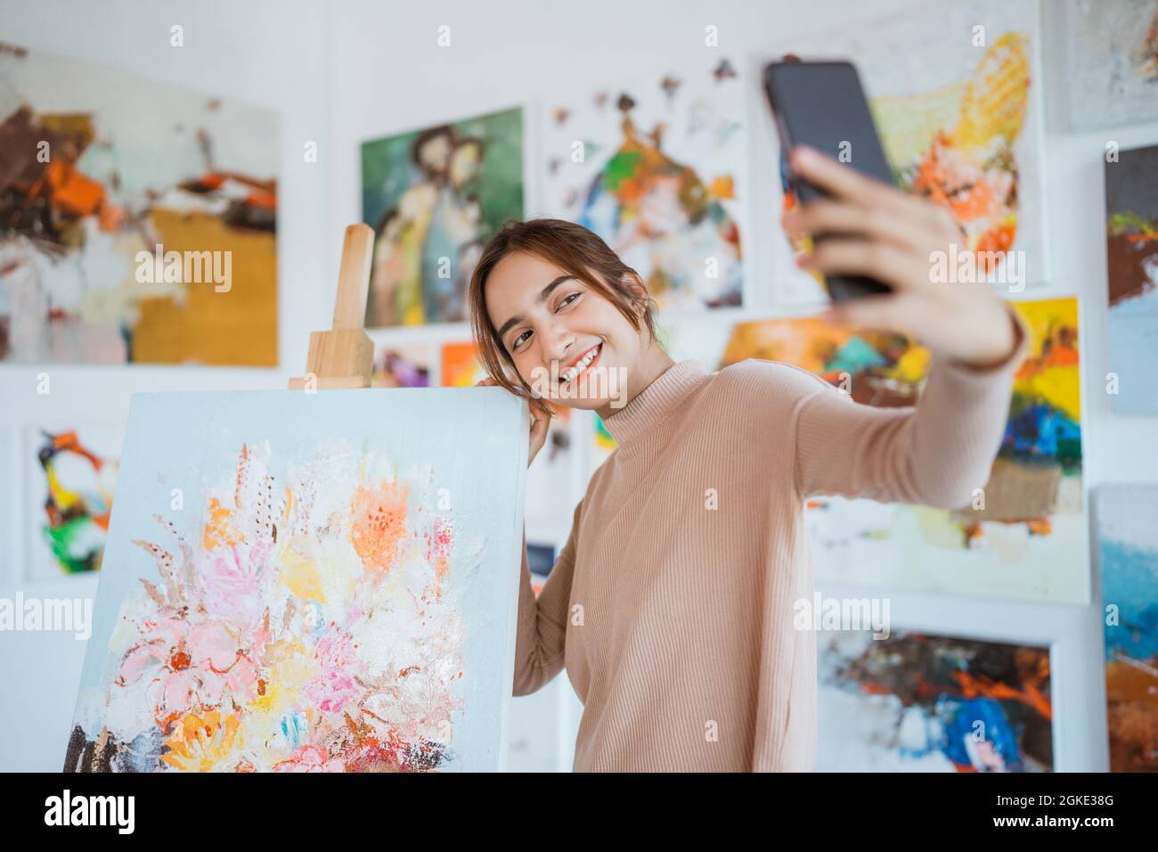artiste asiatique prenant en photo sa propre peinture à l'aide d'un smartphone Banque D'Images