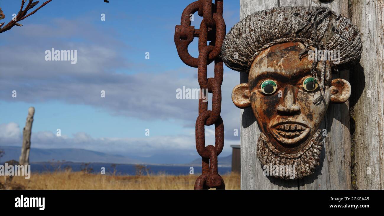 Le portrait d'un masque en bois d'un Africain indigène à côté d'un fond bleu de métal rouillé de la mer, du ciel, des nuages, Reykjavik, Islande Banque D'Images