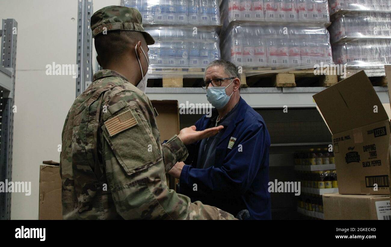 Sergent d'état-major de la Force aérienne des États-Unis Nelson Pacheco, 52e technicien en santé publique du Groupe médical (à gauche), s'entretient avec un membre du personnel de l'économat espagnol lors d'une inspection à la base aérienne de Spangdahlem en Allemagne, le 29 mars 2021. La section de la santé communautaire de la santé publique comprend des programmes tels que des inspections alimentaires et des entrevues sur les infections transmises sexuellement. Banque D'Images