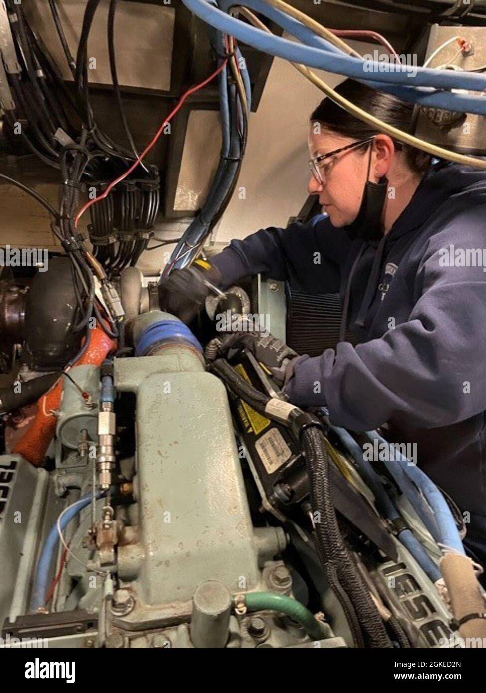 Le MKC Holly Beck ajuste un flexible qui relie le boîtier de coupure d'air au turbo sur un moteur diesel 6V92TA Detroit Banque D'Images