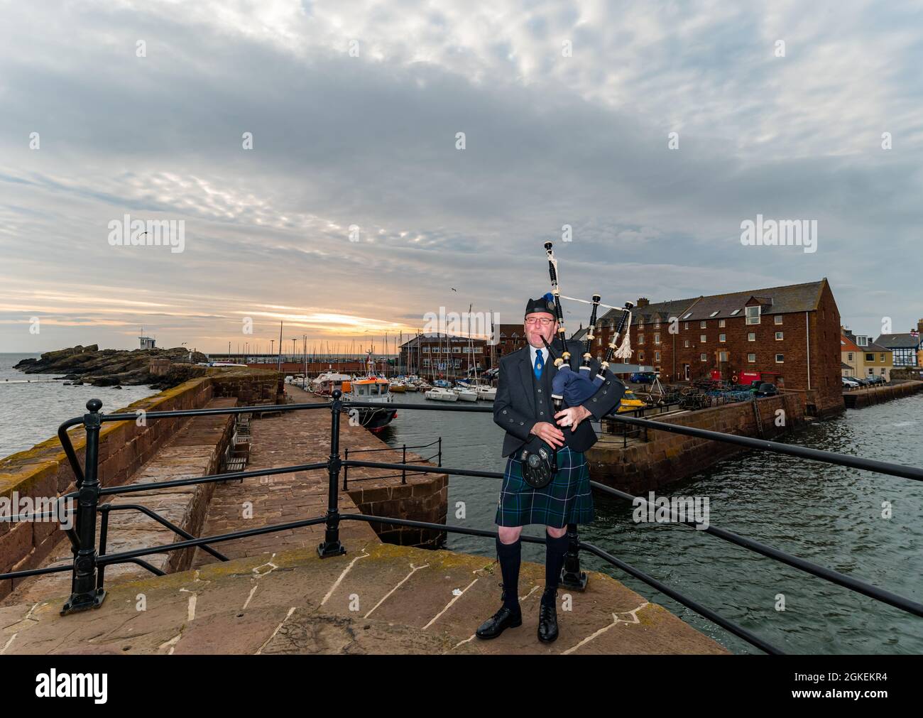 Piper joue des cornemuses à l'aube pour commémorer la St Valery Day (soldats écossais capturés dans la deuxième Guerre mondiale), port de North Berwick, East Lothian, Écosse, Royaume-Uni Banque D'Images