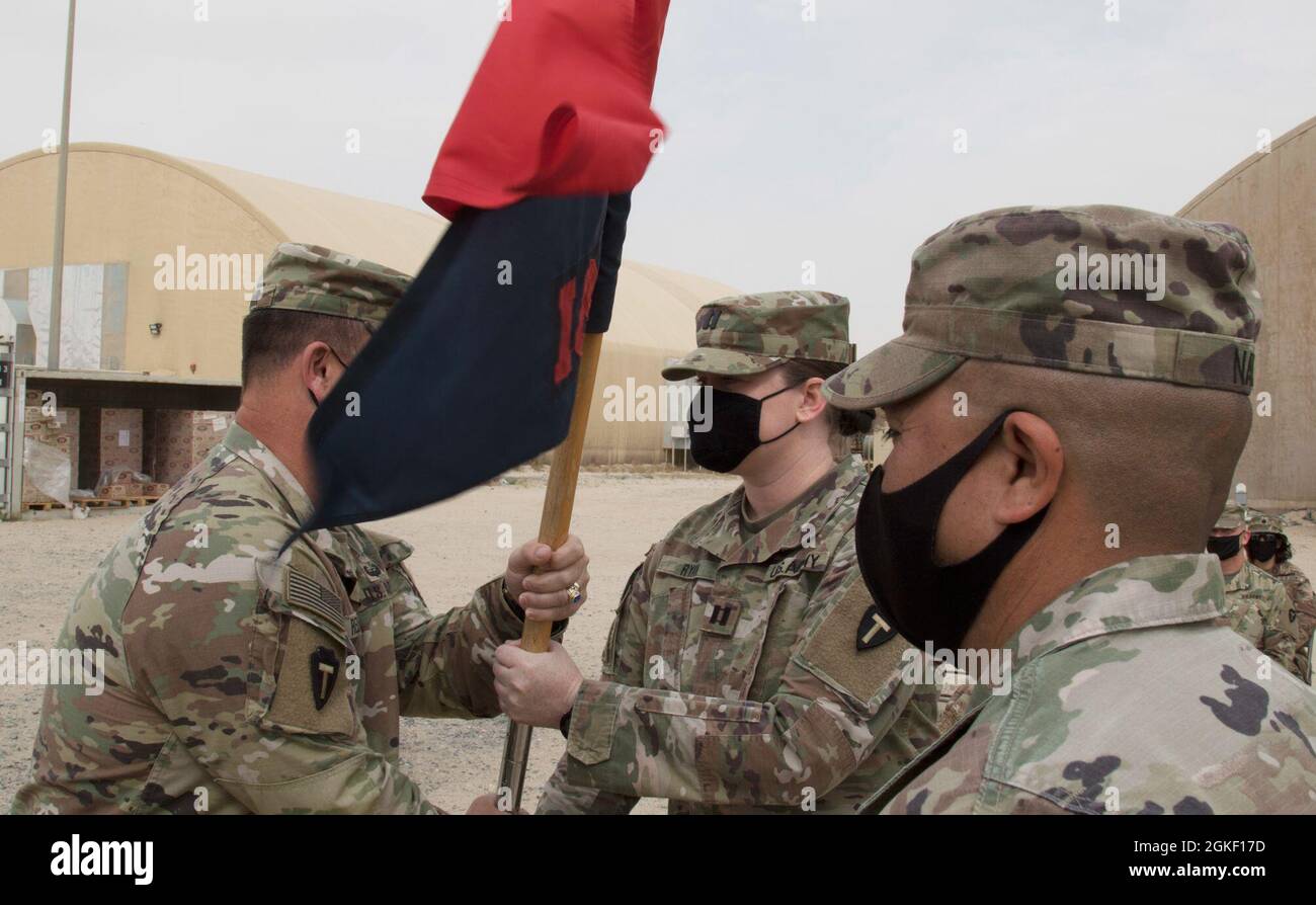Le capitaine Sarah Ryan, commandant entrant de la Compagnie du renseignement et du soutien, Force opérationnelle Spartan, reçoit les directives de la compagnie du lieutenant-colonel Timothy Redhair, commandant du bataillon du quartier général supérieur, Force opérationnelle Spartan, lors d'une cérémonie de changement de commandement, le 3 avril 2021, au Camp Arifjan, au Koweït. Ryan était auparavant responsable du renseignement Open Source pour le G-2, Task Force Spartan, avant de reprendre ses fonctions de commandant de la société I&S. Banque D'Images