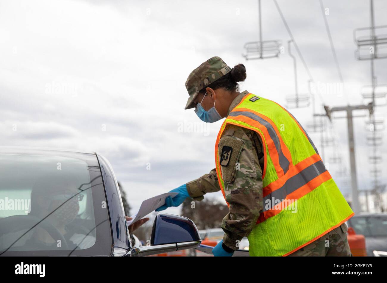 Sergent de l'armée américaine Brayana Elmore, un medic affecté à la 547e Area support Medical Company, 62e Brigade médicale distribue un dépliant de dépistage COVID-19 à un membre de la communauté Yakima au Centre communautaire de vaccination (CVC) de Yakima, Washington, le 4 avril 2021. 62d Med BDE soutient les opérations d'intervention COVID du ministère de la Défense pour distribuer rapidement les vaccins. Le Commandement du Nord des États-Unis, par l'intermédiaire de l'Armée du Nord des États-Unis, demeure déterminé à fournir un soutien continu et souple du ministère de la Défense à l'Agence fédérale de gestion des urgences dans le cadre de la réponse pangouvernementale à la COVID-1 Banque D'Images