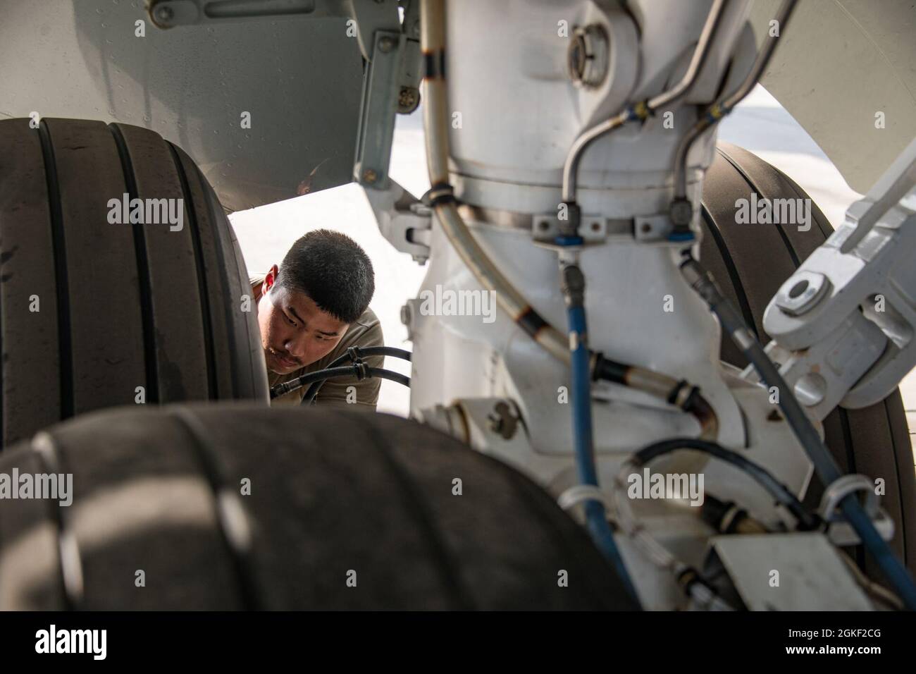 L'Airman de la U.S. Air Force Joshua Elmore, chef d'équipage du 379e Escadron de maintenance des aéronefs expéditionnaires, vérifie le système de freinage d'un avion joint RC-135 Rivet le 28 janvier 2021, à la base aérienne Al Udeid, au Qatar. Elmore a étudié le génie mécanique pendant un an à l'université avant de décider de rejoindre la Force aérienne l'année dernière. Banque D'Images