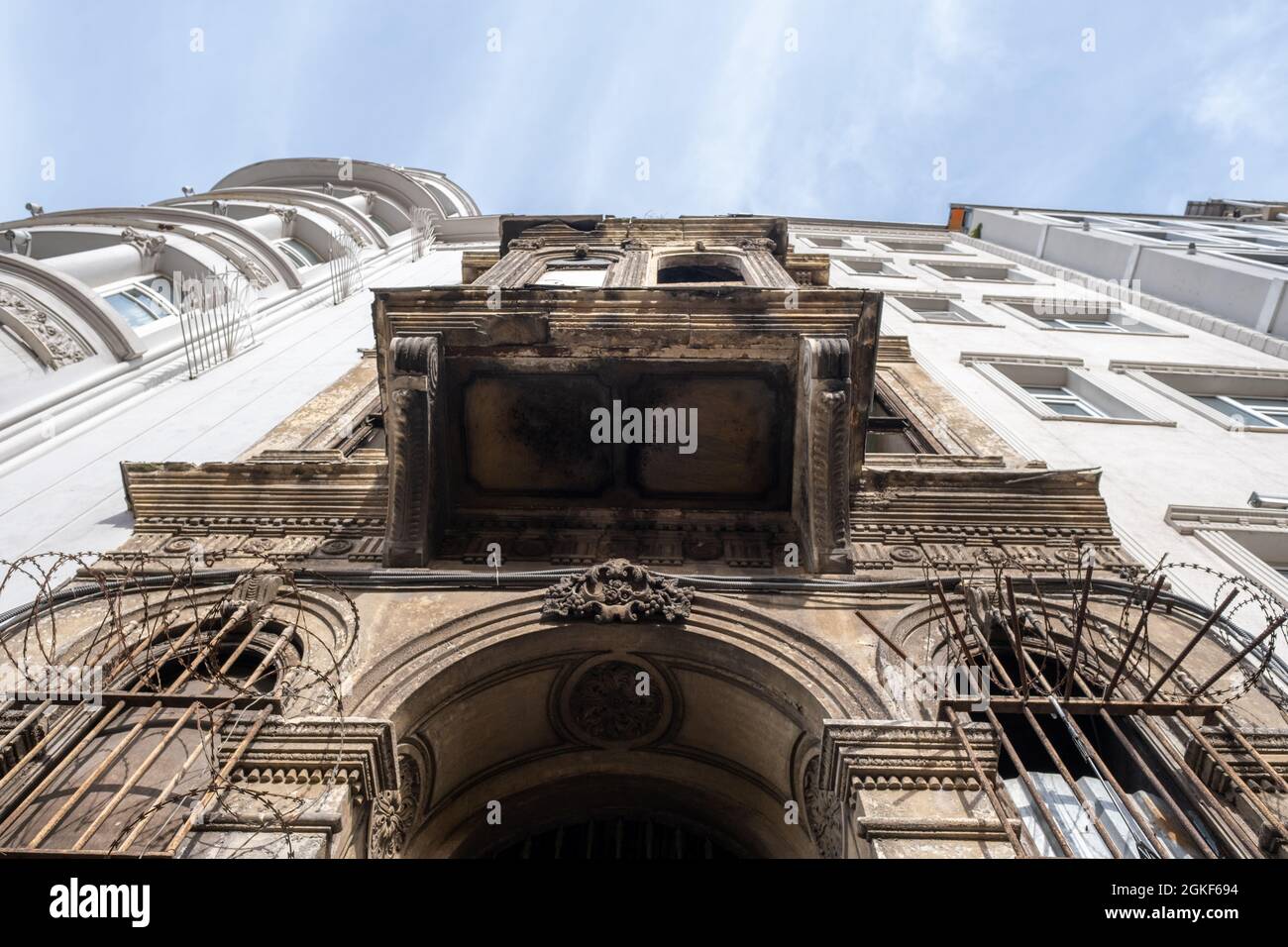 Taksim, Istanbul, Turquie - 03.12.2021: Vue à angle bas d'un vieux bâtiment historique ruiné et de nouveaux bâtiments modernes entre eux sous ciel bleu Banque D'Images