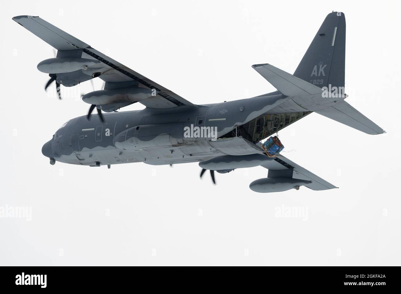 Un roi de combat HC-130J de la Garde nationale aérienne de l'Alaska exploité par des aviateurs du 211e Escadron de sauvetage larme un système de livraison de conteneurs lors d'opérations aériennes au-dessus de la zone de chute de Malemute à la base conjointe Elmendorf-Richardson (Alaska), le 7 avril 2021. Le HC-130J combat King II est une version spécialement modifiée et améliorée du très connu C-130 Hercules. Il peut effectuer des opérations de récupération du personnel, des missions de recherche et de sauvetage, ainsi que des missions de ravitaillement en vol par hélicoptère aérien et de ravitaillement au sol. Banque D'Images