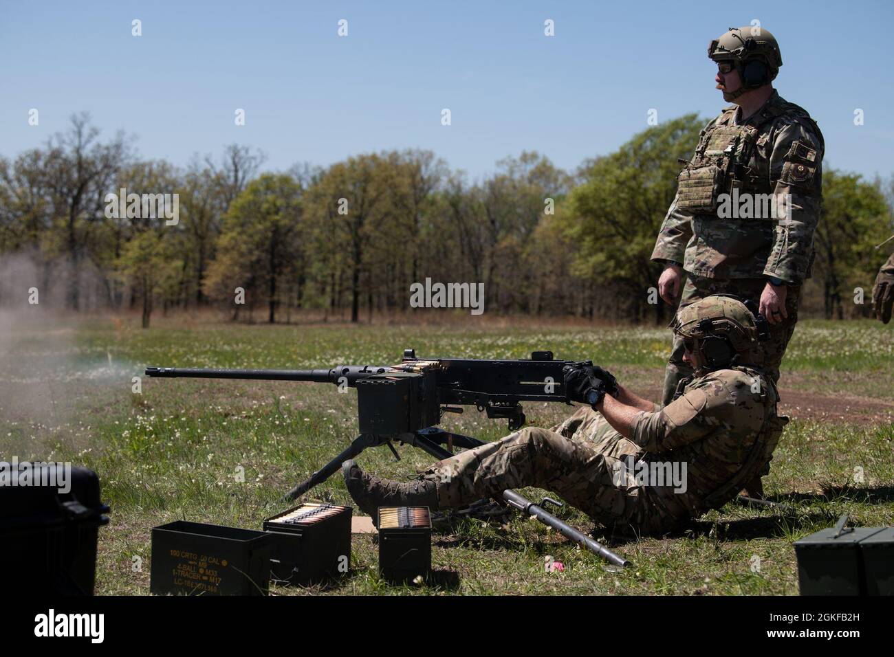 Le commandant principal Airman Conner Goodwin, spécialiste tactique du parti de contrôle aérien du 146e Escadron des opérations de soutien aérien (146e Escadron), observe le sergent d'état-major. Matthew Calvert, instructeur d'armes de combat au 137e Escadron des forces de sécurité des opérations spéciales, lors de l'entraînement de familiarisation sur la mitrailleuse de calibre M2A1 .50 à Razorback Range, près de fort Smith, Arche., le 4 avril 2021. Le M2A1 est une mise à niveau de la populaire mitrailleuse M2 et aide à protéger les aviateurs Special Warfare contre les véhicules blindés légers, les avions volants bas et lents et le personnel ennemi, que le 146e ASOS pourrait rencontrer Banque D'Images