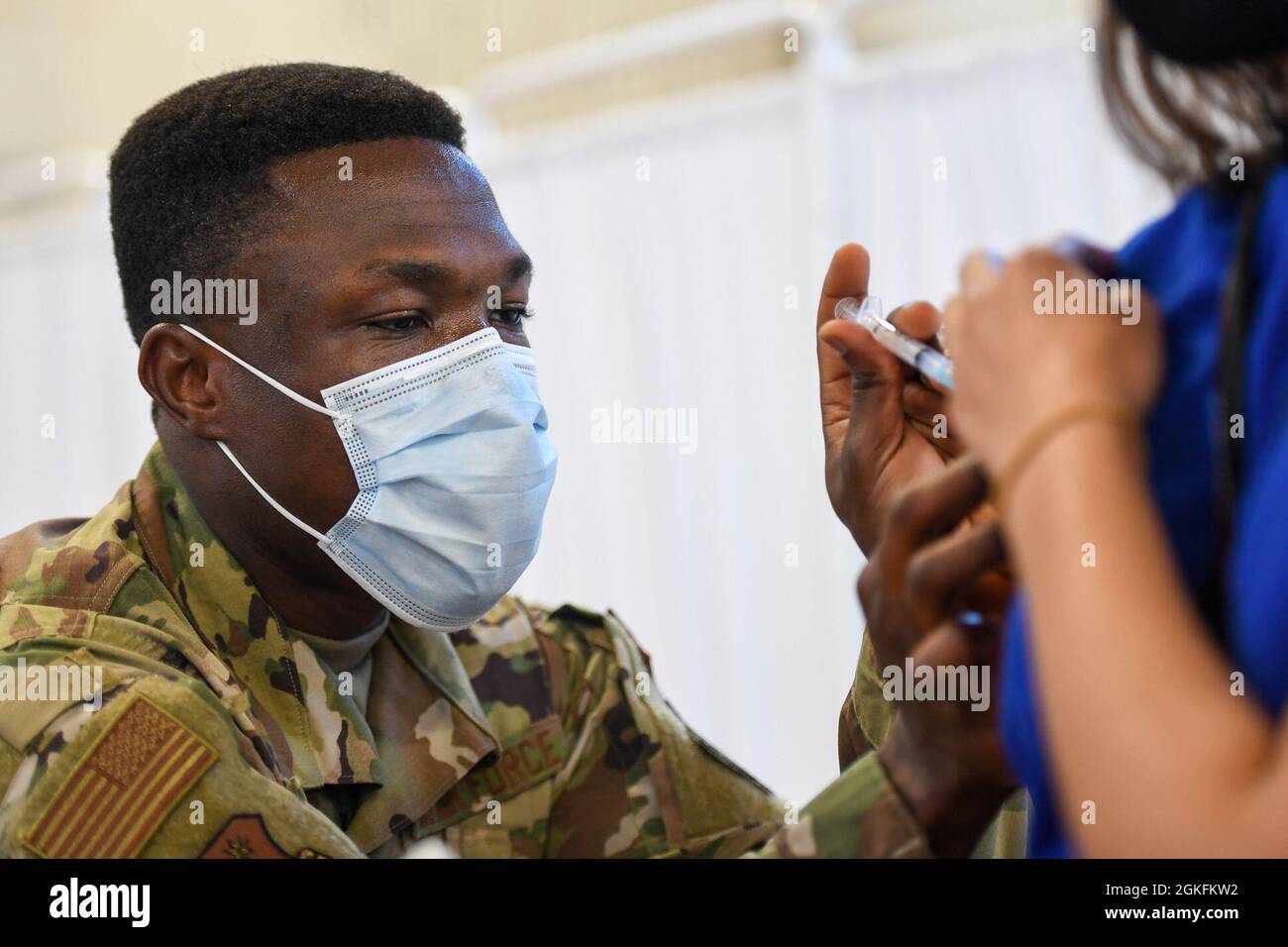 Sergent d'état-major Jude Baidoo, technicien médical du 66e Escadron de médecine, administre le vaccin COVID-19 à Meera Punjiya, personnel technique du laboratoire Lincoln du MIT, à la base aérienne Hanscom, Massachusetts, avril 9. Hanscom a élargi l'admissibilité aux vaccins pour inclure tout le personnel de base dans les niveaux 1 et 2, tel que défini par le schéma de priorisation du ministère de la Défense Banque D'Images