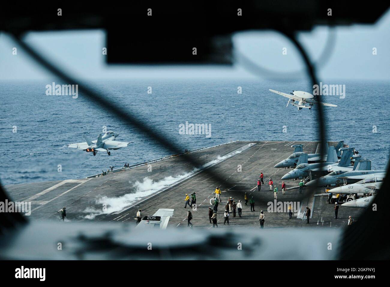 MER DE CHINE DU SUD (10 avril 2021) – un Super Hornet F/A-18F, affecté au « Black Knights » du Strike Fighter Squadron (VFA) 154, à gauche, Et un E-2C Hawkeye, affecté aux “Liberty Bells” de l'escadron de commandement et de contrôle aéroporté (VAW) 115, à partir du pont de vol du porte-avions USS Theodore Roosevelt (CVN 71) le 10 avril 2021. Le groupe de grève des transporteurs Theodore Roosevelt est en cours de déploiement prévu dans la zone d'exploitation de la 7e flotte des États-Unis. En tant que plus grande flotte déployée à l’avant de la Marine américaine, la 7e flotte opère et interagit régulièrement avec 35 nations maritimes tout en effectuant des missions Banque D'Images