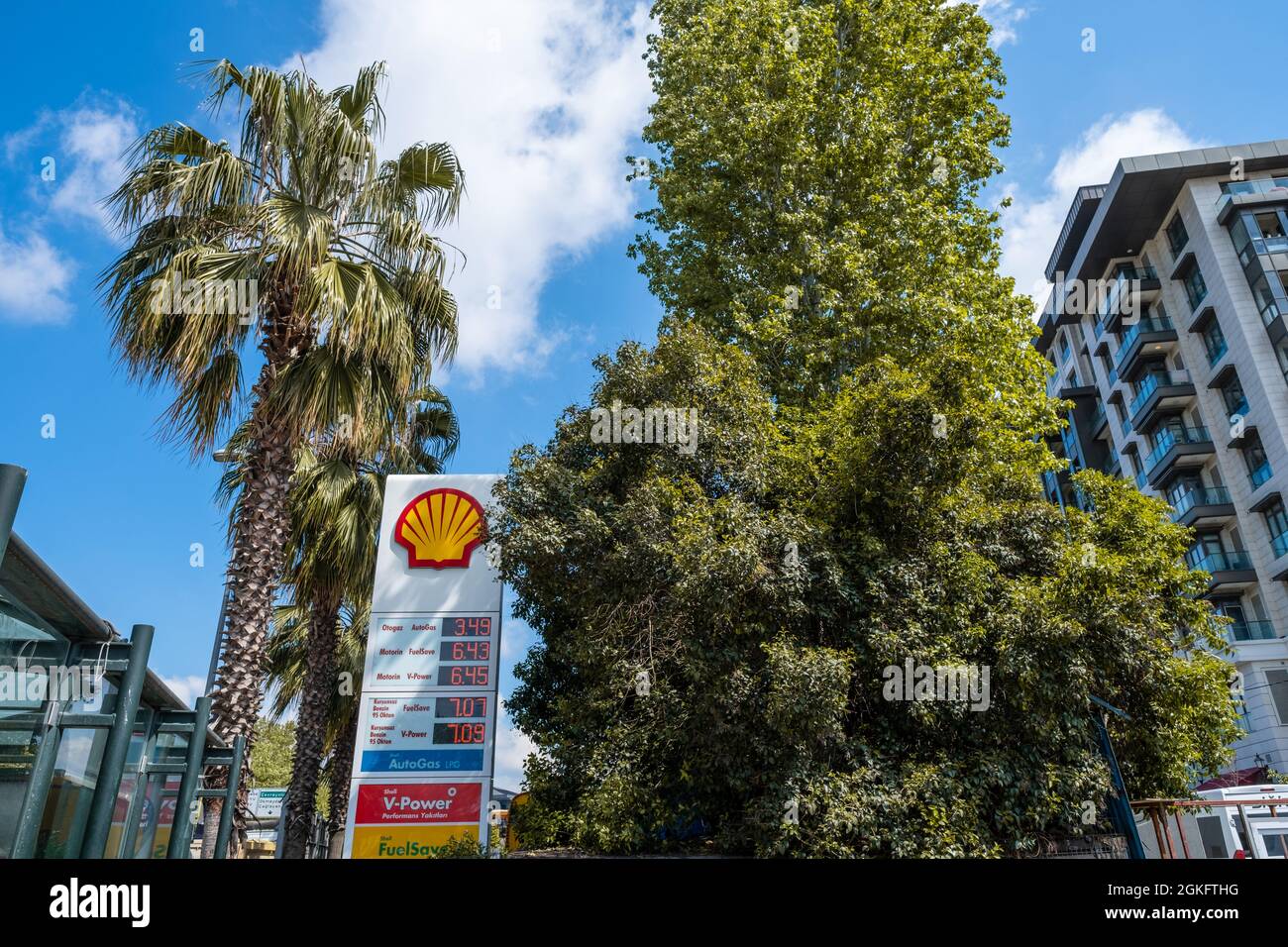 Beyoglu, Istanbul, Turquie - 05.17.2021: Marque de station-service Turque Shell et vert feuilles jaunes décolorées d'arbres sous ciel bleu et nuages blancs avec co Banque D'Images