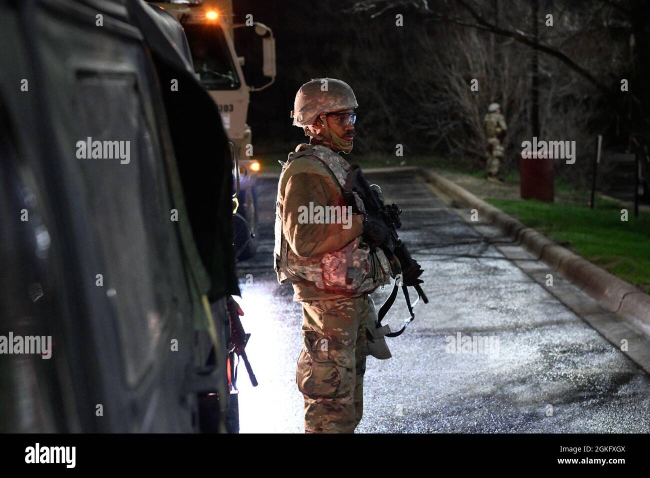 Les soldats de la Garde nationale du Minnesota gardent la garde, renforçant ainsi les forces de l'ordre locales au Brooklyn Center, Minnesota, le 13 avril 2021, la nuit qui a suivi les troubles initiaux dans la région. Plus de 2,000 soldats et aviateurs ont été activés à l'appui de l'opération Safety Net, un effort coordonné visant à protéger les droits des manifestants pacifiques et à assurer la sécurité du public pendant le procès de Derek Chauvin. Les organisations participant à l'opération Safety Net s'engagent à protéger les personnes, les biens et la liberté d'expression.​ Banque D'Images