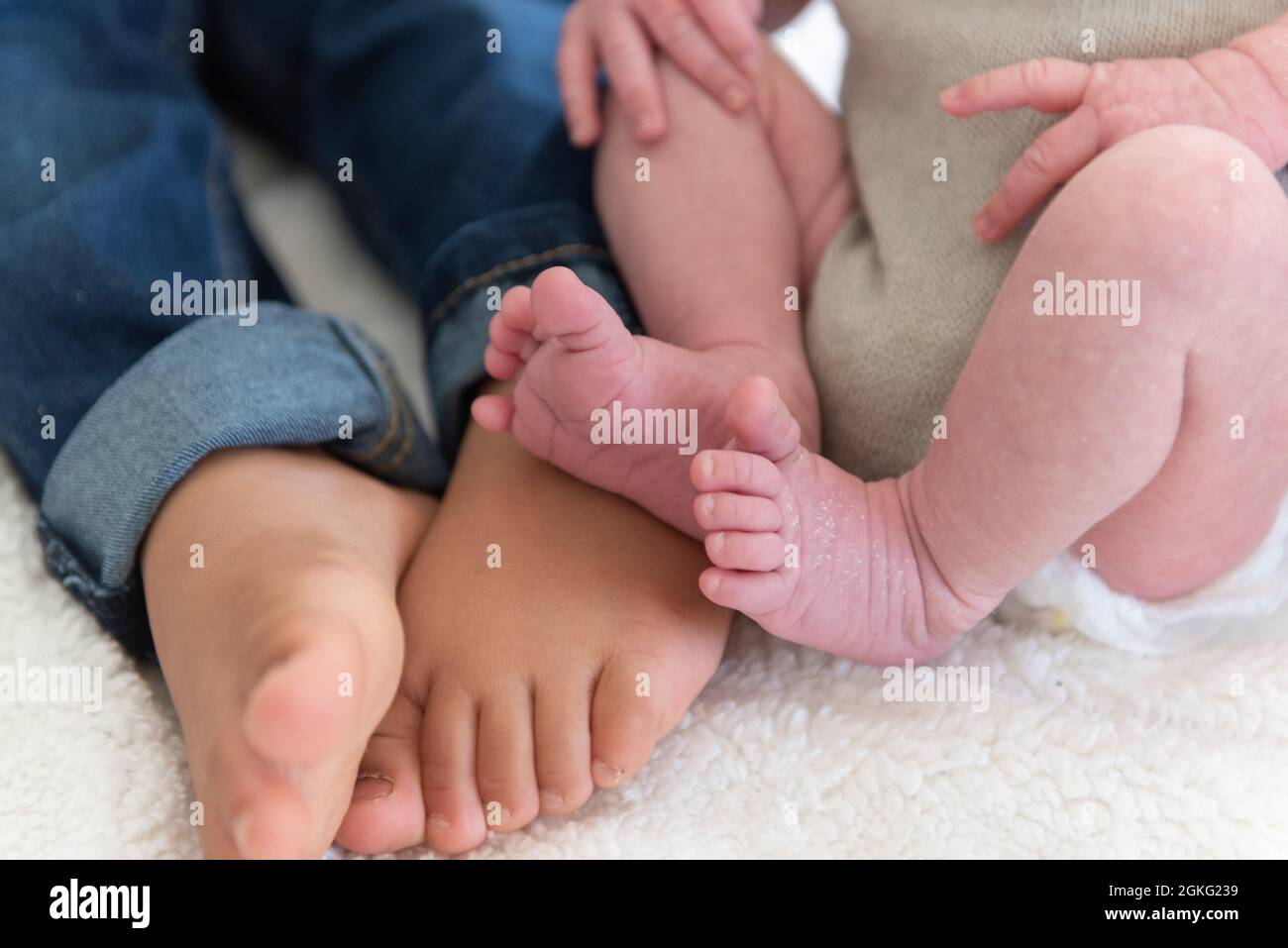 Les pieds et les orteils du grand frère et de la petite sœur du nouveau-né  sont comparés ensemble pour la taille Photo Stock - Alamy