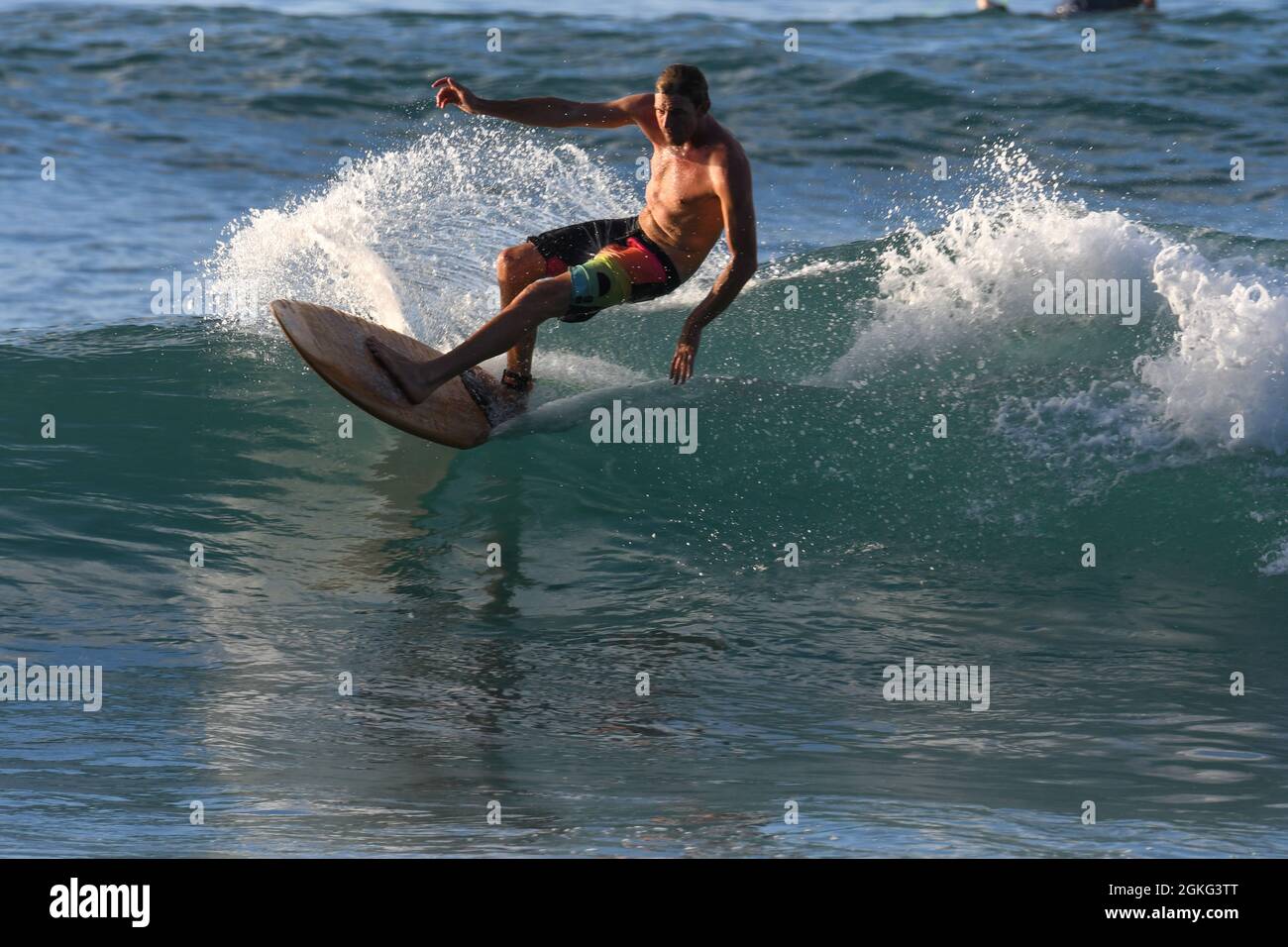 Surfez sur les vagues turquoise des Caraïbes au coucher du soleil Banque D'Images