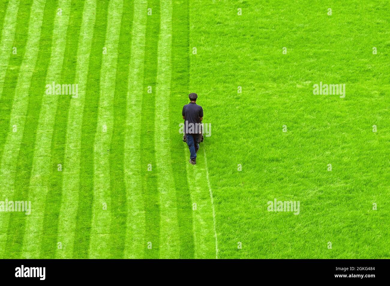 Londres, Angleterre - août 2021 : vue aérienne d'une personne fauchant une pelouse dans un parc public avec des rayures coupées dans l'herbe Banque D'Images