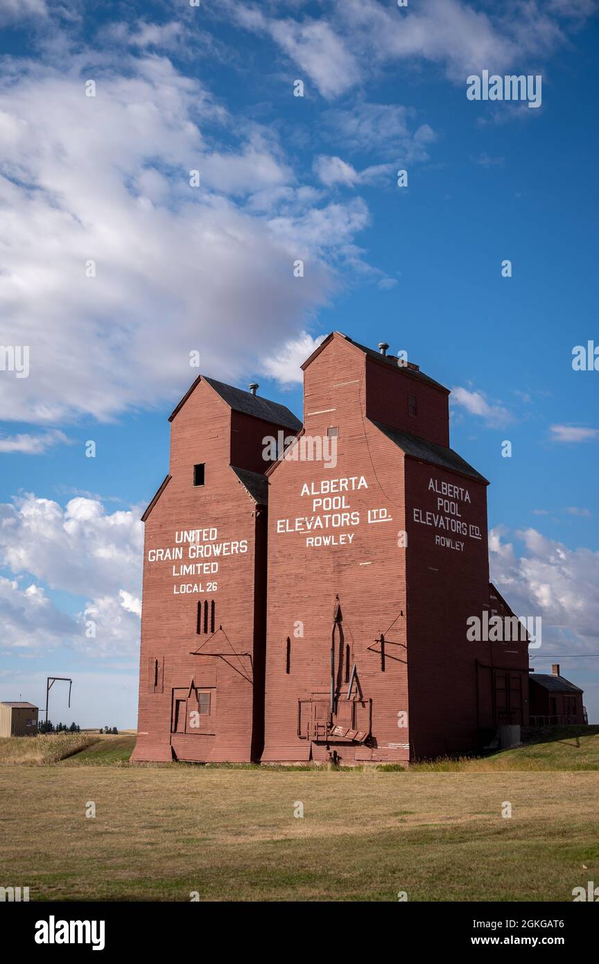 ROWLEY, CANADA - 06 septembre 2021 : un cliché vertical des silos à grains historiques en bois de la ville fantôme de Rowley, en Alberta, avec un ciel bleu Banque D'Images