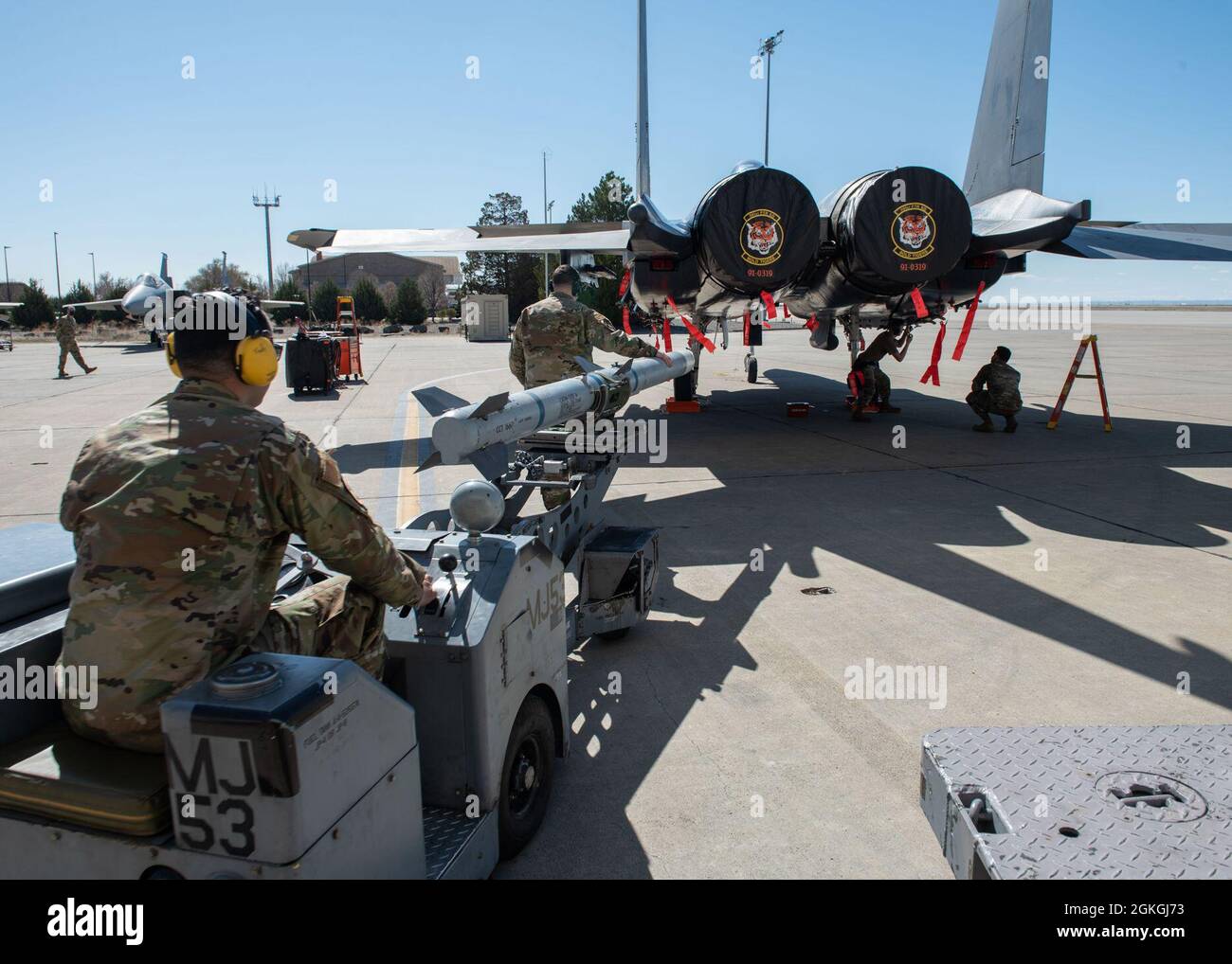 L'aviateur principal de la Force aérienne des États-Unis, Fadi Aidenberg, membre de l'équipage de chargement du 391e Escadron de chasseurs, conduit un véhicule de brouilleur à un aigle de grève F-15E, avec l'aide du sergent d'état-major. Tryton Barnes, 391e membre de l'équipage de charge du FS, le 16 avril 2021, à la base aérienne de Mountain Home, Idaho. Dans cette compétition, chaque équipe doit charger deux missiles Air Intercept dans l'avion en 17 minutes ou moins. Banque D'Images