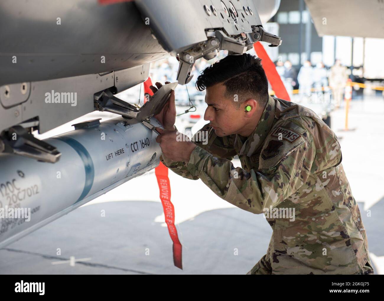 L'Airman Christian Gerado, principal de la U.S. Air Force, membre de l'équipage du 389e Escadron de chasseurs, sécurise une ailette à un missile Air Intercept, le 16 avril 2021, à la base aérienne de Mountain Home, Idaho. Bien que la vitesse soit un facteur important dans la compétition, les aviateurs doivent également être précis lors du chargement des munitions dans l'avion. Banque D'Images