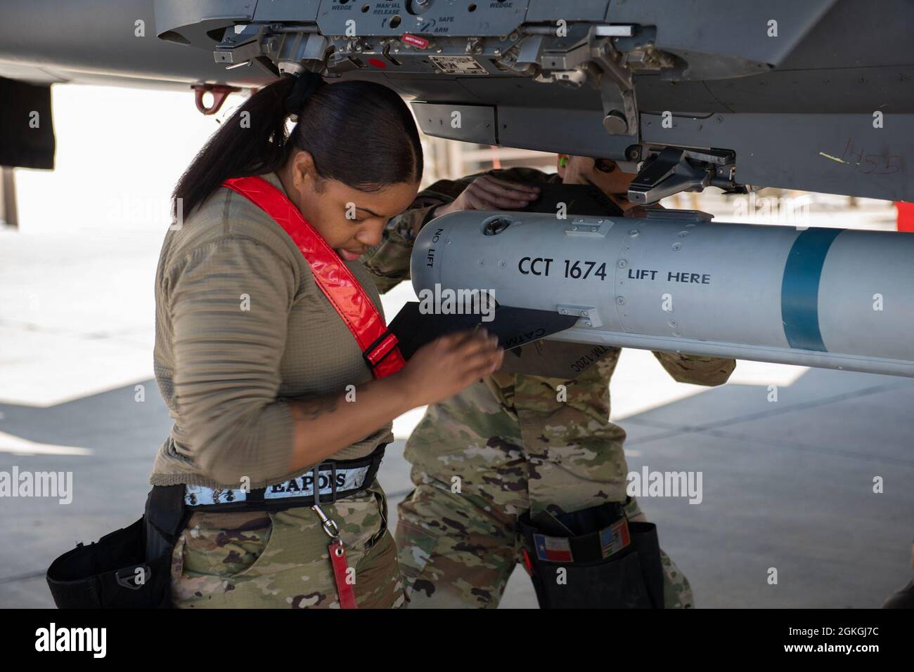Airman principal de la US Air Force Autumn Willingham, membre de l'équipage du 389e Escadron de chasseurs, installe une ailette sur un missile Air Intercept, le 16 avril 2021, à la base aérienne de Mountain Home, Idaho. Le concours trimestriel de l'équipage de charge teste la vitesse et les compétences d'un équipage de trois personnes qui charge des munitions dans un avion. Banque D'Images
