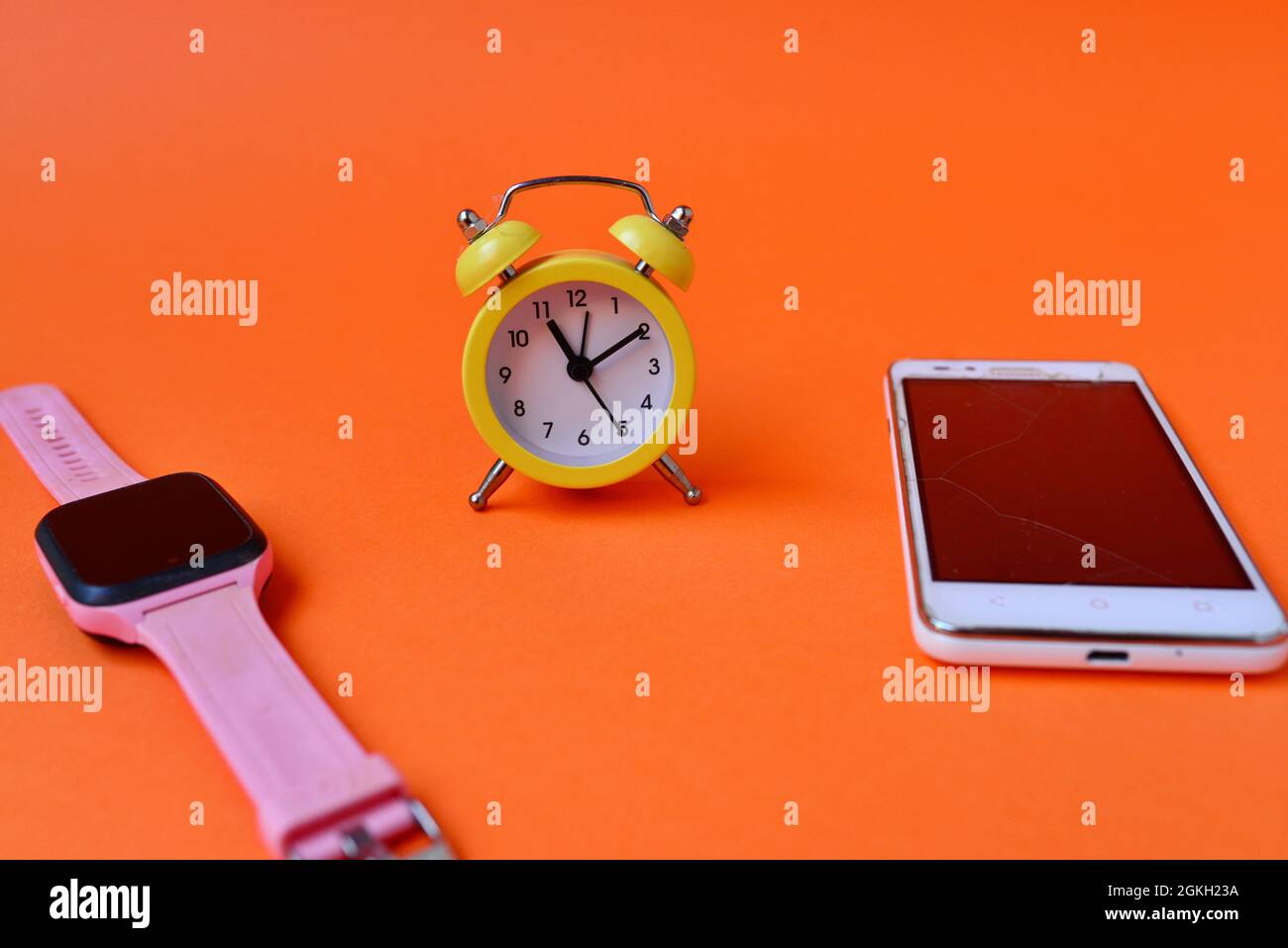 Horloge intelligente, réveil et smartphone sur fond orange Photo Stock -  Alamy