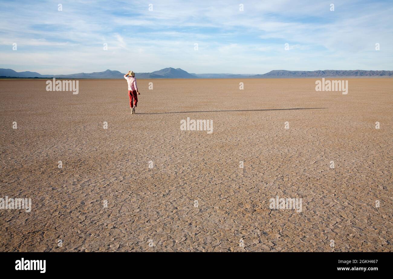 Femme marchant seule sur une plage désertique sèche, dans le sud-est de l'Oregon, aux États-Unis Banque D'Images