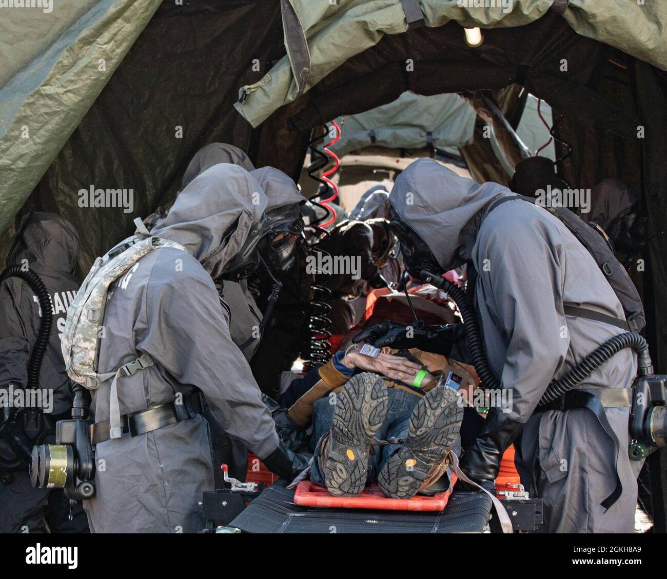 210421-A-ST150-Mosque Decon420 // des spécialistes en chimie, biologie, radiologie et nucléaire avec la Garde nationale de l'armée de Californie, 140e compagnie chimique, communiquent pour élever le civil notionnel blessé sur une ceinture de décontamination pendant l'entraînement au centre d'entraînement urbain de Muscatatuck, Ind., 21 avril 2021. Les spécialistes CBRN ont mené une formation en décontamination en éliminant les substances chimiques théoriques et radioactives sur des civils blessés et des membres de service basés sur des scénarios. Banque D'Images