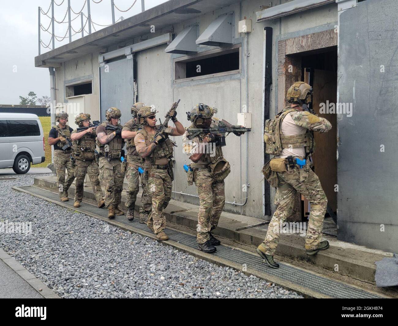 CAMP HANSEN, Okinawa Japon - des bérets verts de l'armée américaine avec le 1er Groupe des forces spéciales (aéroporté) entrent et dépodent un bâtiment endommagé pendant l'entraînement à action directe (DA) le 2021 avril, à Camp Hansen, Okinawa Japon. L’exercice de formation a porté sur la capacité des bérets verts à améliorer les procédures de DA en matière de braconnage, de lutte contre les dispositifs explosifs improvisés et les directives post-agression tout en renforçant les partenariats avec la formation stratégique dans l’ensemble de l’Indo-Pacifique. Banque D'Images