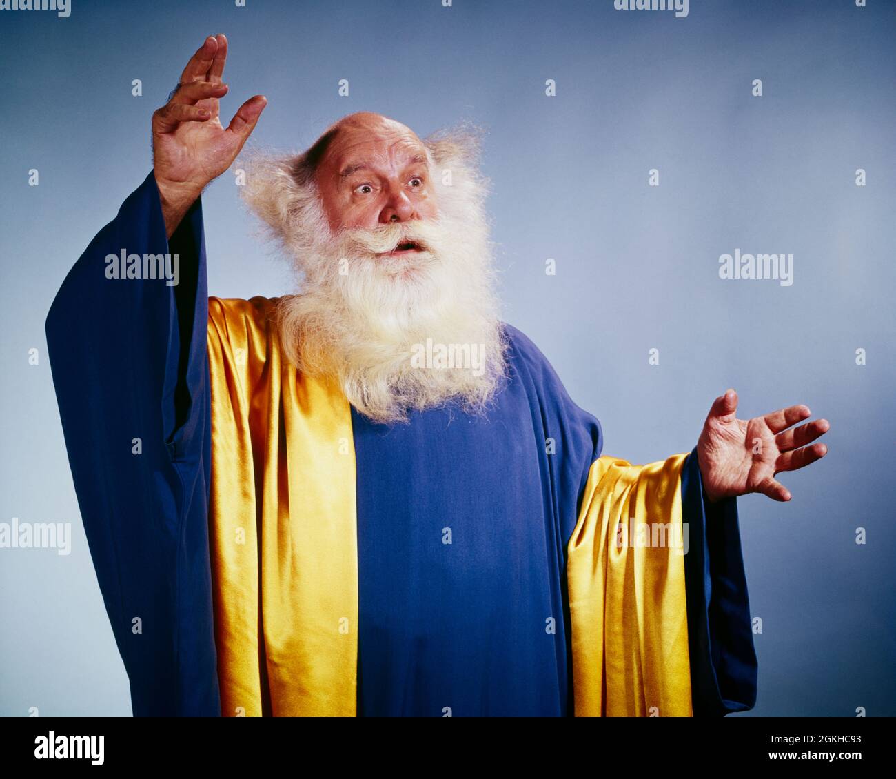 PERSONNAGE HOMME ÂGÉ DES ANNÉES 60 AVEC BARBE BLANCHE ROBES LONGUES BLEU ET OR BRAS LEVÉS PRÉDICATEUR MYSTIC SEER ORACLE FORTUNE TELLER - KC3409 HAR001 HARS CARRIÈRE RELEVÉE MYSTÈRE FORTUNE STYLE DE VIE ACTEUR RELIGION AÎNÉE EMPLOIS STUDIO PRISE DE VUE ROBE COPIER ESPACE PLEINE LONGUEUR DEMI-LONGUEUR PERSONNES INSPIRATION PERSONNAGE HOMMES PSYCHIQUE PROFESSION SPIRITUALITÉ CONFIANCE SENIOR HOMME SENIOR COMPÉTENCE ADULTE WONDER AWE RÊVES PROFESSION COMPÉTENCES VIEILLESSE OLDSTERS OLDSTER AVENTURE DÉCOUVERTE ARTISTES ROBES ET SEER FORTUNE TELLER CARRIÈRES PERSONNAGES EXCITATION LEADERSHIP BAS ANGLE PUISSANT VOYANCE ORACLE AUTORITÉ ANIMATEUR Banque D'Images