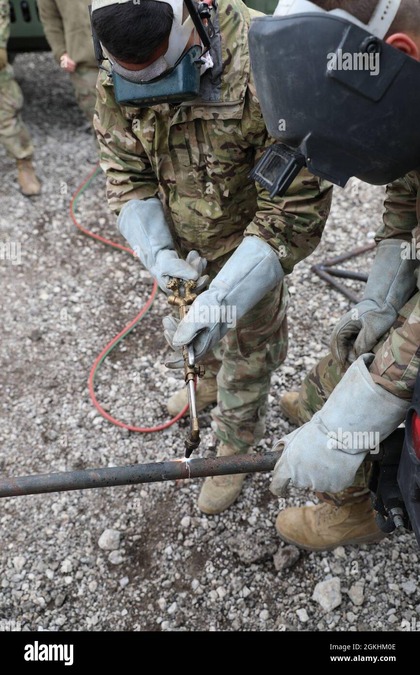 SPC de la Réserve de l'armée américaine. Jimmy Aparicio (à gauche), mécanicien de véhicules à roues pour le 215e détachement mobile des affaires publiques de la Nouvelle-Orléans, en Louisiane, aux côtés de la CPS. Phoenix MacRabie, mécanicien de véhicules à roues du 204e Bataillon de génie de la Garde nationale de l’Armée de terre de New York, coupe un tuyau pendant la réaction du Guardian Response 21 au Muscatatuck Urban Training Center, Ind., 24 avril 2021. L'intervention du tuteur est un exercice d'intervention d'urgence en territoire national commandé par la 78e Division d'entraînement pour simuler la formation d'intervention en cas de catastrophe afin d'affiner les compétences et d'accroître les capacités des soldats de la Réserve de l'Armée de terre des États-Unis Banque D'Images