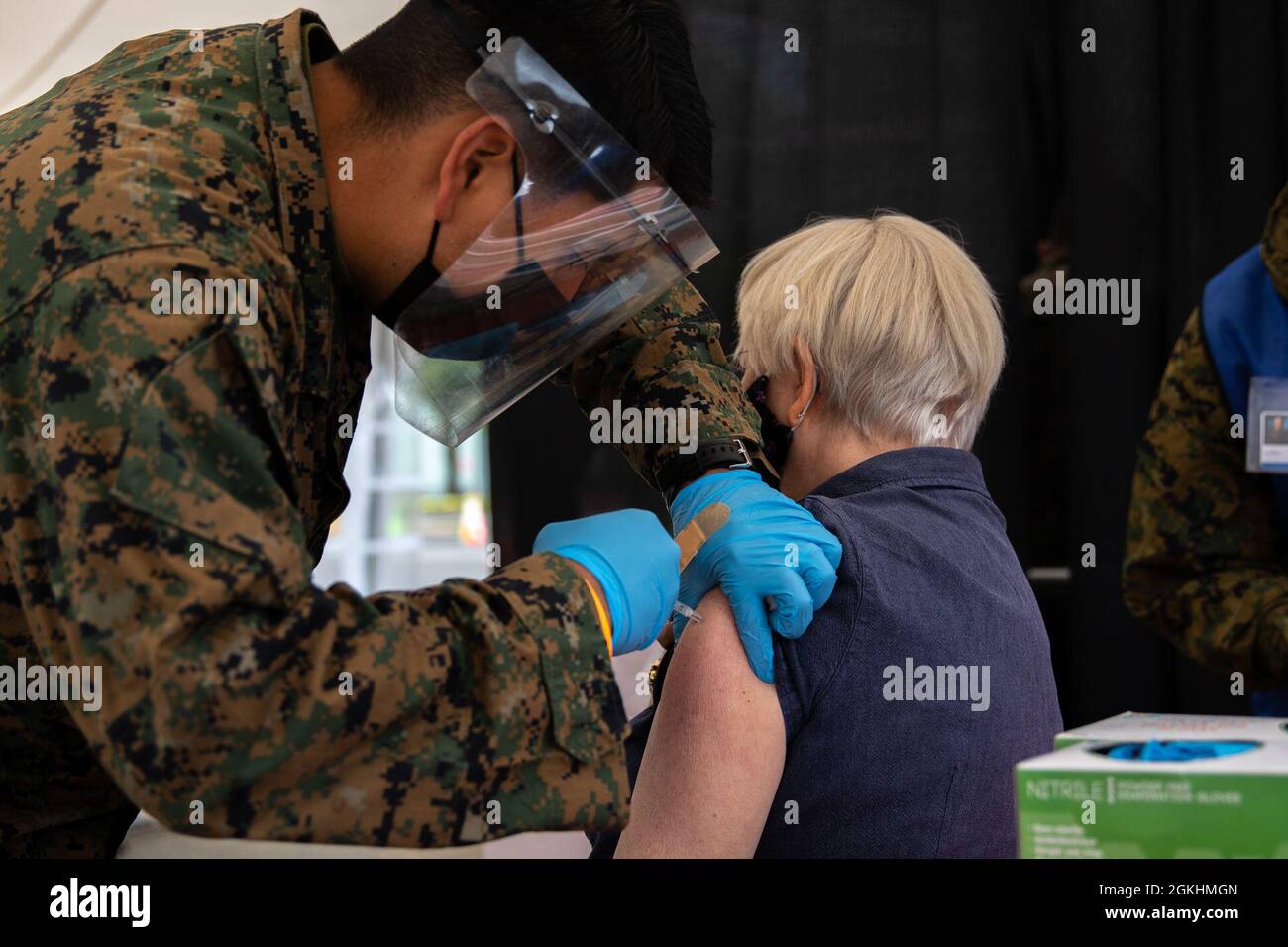 L'Hospitalman de la Marine américaine Raymond Salgado, 1er Bataillon médical, 1er Groupe de logistique maritime, I Marine Expeditionary Force (MEF) vaccine un patient au Centre communautaire de vaccination (CVC) à l'exposition du comté de Jackson à Central point, Oregon, le 25 avril 2021. Marines et marins affectés à I MEF déployés à partir de la base du corps des Marines Camp Pendleton, en Californie, à l'appui des opérations d'intervention COVID du ministère de la Défense pour aider les communautés dans le besoin. Le Commandement du Nord des États-Unis, par l'entremise de l'Armée du Nord des États-Unis, demeure déterminé à fournir un soutien continu et souple du ministère de la Défense au Feder Banque D'Images