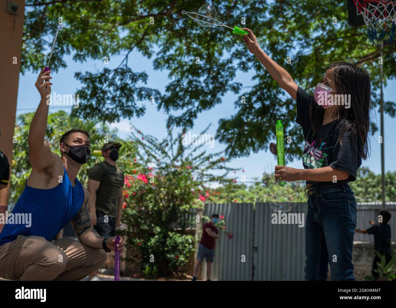 Sergent d'état-major de la Force aérienne des États-Unis Nathan King, chef d'équipe de prévention des incendies au 612e Escadron de la base aérienne de Soto Cano, au Honduras, montre à un enfant de la Fondation enfants d'amour comment créer des bulles lors d'une visite à la Paz, au Honduras, le 25 avril 2021. L'orphelinat fonctionne depuis 28 ans, nourrissant et vêtant les enfants qui y vivent avec la plupart des dons en provenance des États-Unis Banque D'Images