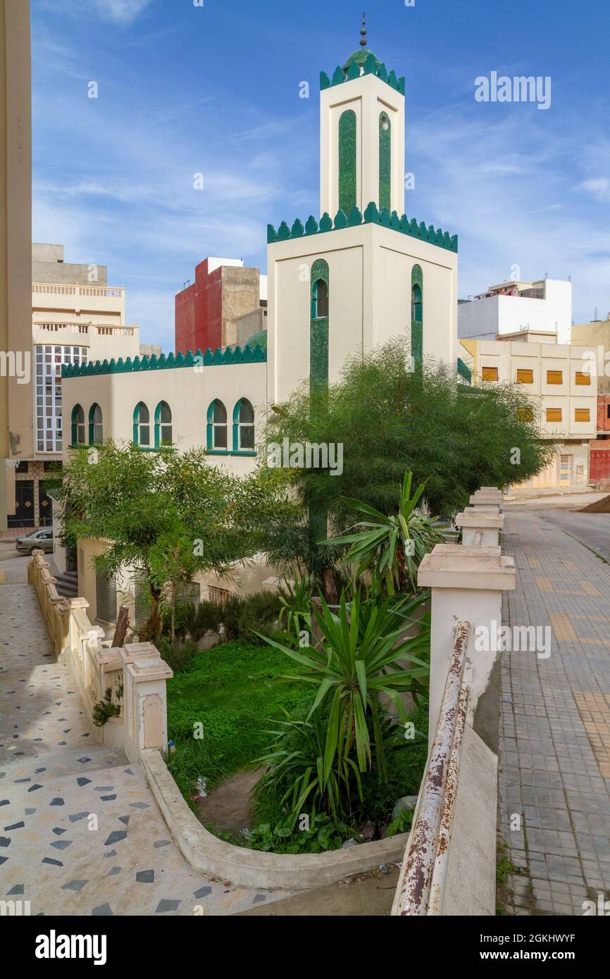 Petite mosquée de quartier dans une banlieue de Tanger avec des décorations vertes et des plantes dans un petit jardin avec un beau ciel bleu Banque D'Images