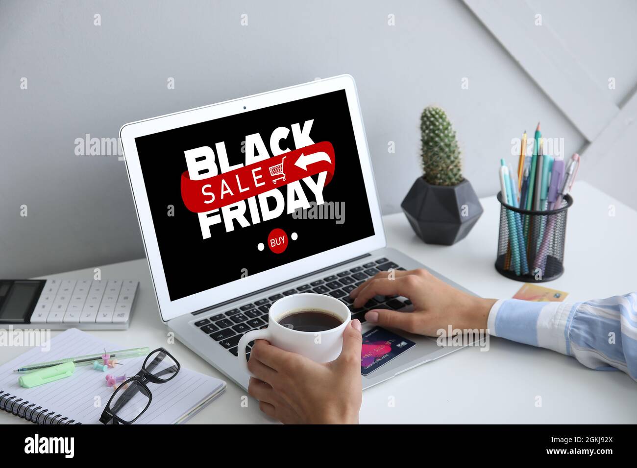 Jeune femme avec ordinateur portable shopping en ligne sur le Black Friday  dans le bureau Photo Stock - Alamy