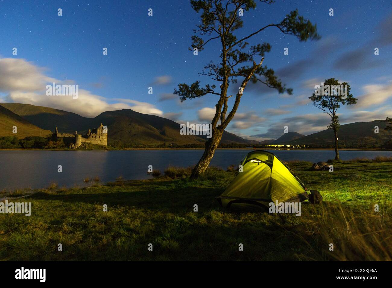 Vue sur le château de Kilchurn illuminé par la lumière de la lune la nuit avec tente, Loch Awe, Écosse Banque D'Images