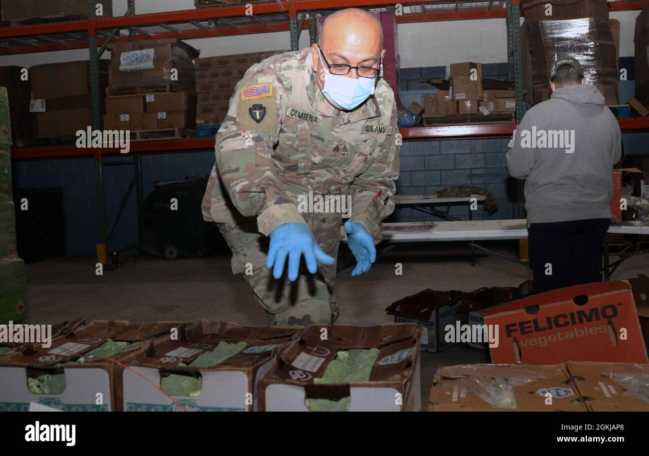 Un soldat affecté à la 5e Brigade blindée, la première division de l'Armée de l'Ouest, atteint pour prendre une boîte lors d'un service communautaire avec la banque alimentaire El Pasoans Fighting Hunger Food Bank à El Paso, Texas, le 30 avril 2021. La brigade des sapeurs a soutenu la mission de la banque alimentaire, qui est de lutter contre la crise de la faim dans la ville en distribuant des aliments nutritifs par l'intermédiaire de partenaires communautaires. Le 5e AR BDE continue de collaborer avec les unités de la Garde nationale et de la Réserve dans toutes les branches militaires et des préparer à se déployer dans la voie du mal et à retourner à leurs familles par la suite. Banque D'Images
