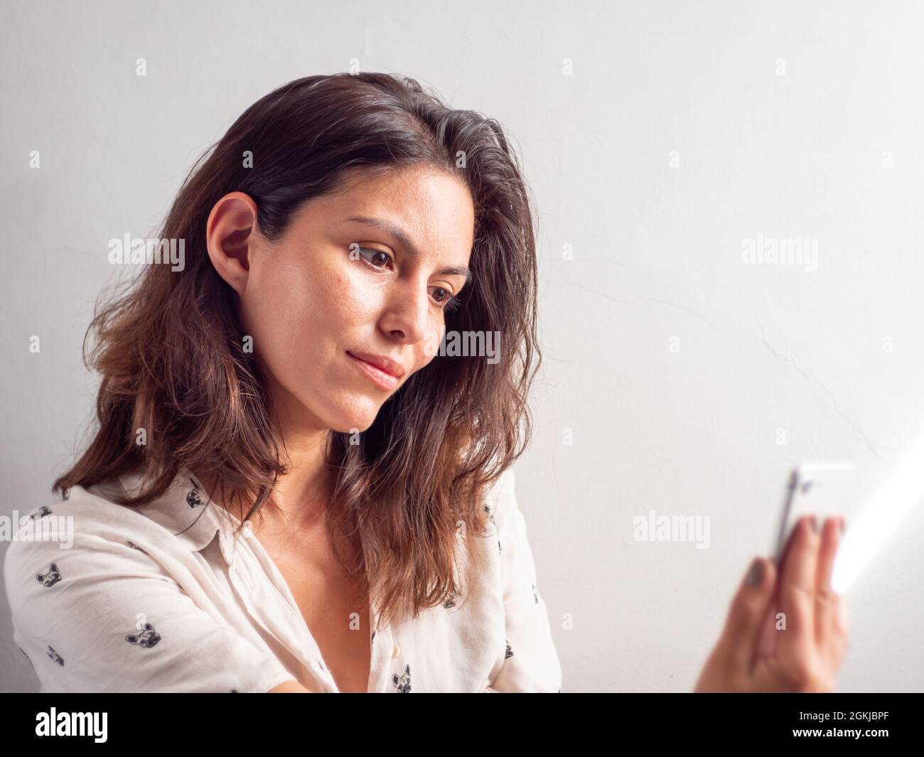 Jeune femme péruvienne à cheveux bruns pose pour un Selfie avec son smartphone Banque D'Images