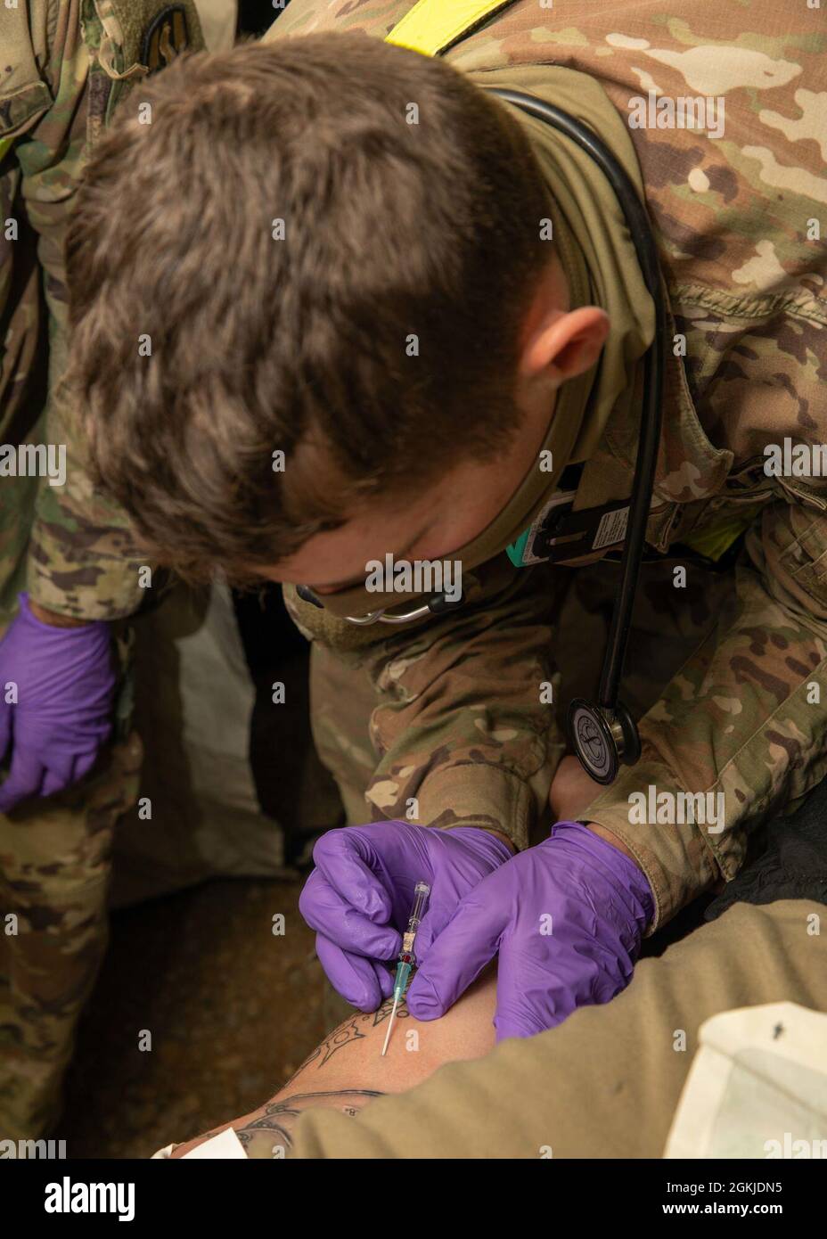 210501-N-PC620-0082 BUTLERVILLE, Ind. (1er mai 2021) SPC de l'armée américaine. Daniel Schantin, affecté à la 546e Area support Medical Company, insère un IV dans le bras d’une victime fictive dans le cadre d’une formation médicale au cours de l’exercice Guardian Response 21 (GR 21) au Muscatatuck Urban Training Center, Indiana, le 1er mai 2021. Le GR 21 est un exercice annuel utilisé pour former et évaluer l'entreprise d'intervention chimique, biologique, radiologique et nucléaire (CBRN) du ministère de la Défense. À la fin de l'événement de formation, les unités attribuées au CRE sont mises en place pour se déployer rapidement afin de prendre en charge l'absence de notic Banque D'Images