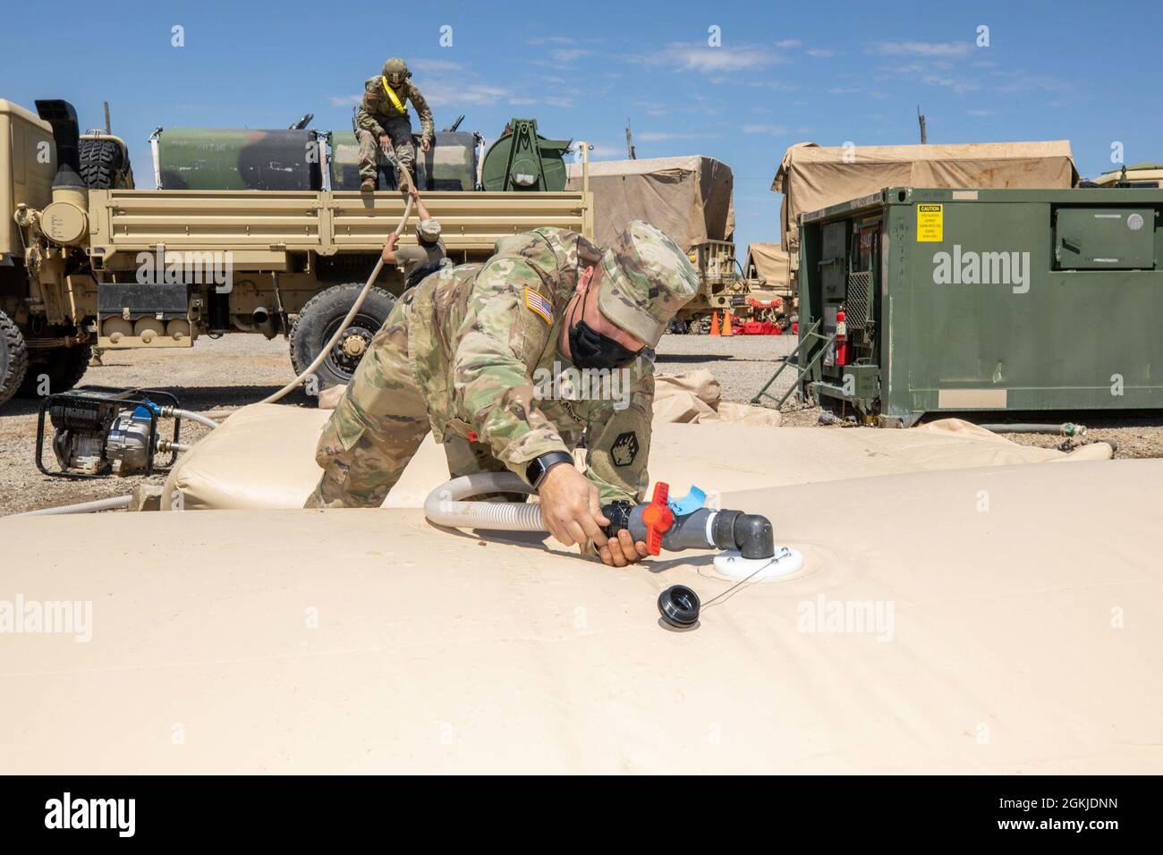 210501-N-PC620-0106 BUTLERVILLE, Ind. (1er mai 2021) SPC de l'armée américaine. Joshua Ashley, affecté à la 44e Chemical Company, remplit un robinet d'eau fournissant de l'eau à une ligne de décontamination de masse qui élimine la contamination chimique, biologique, radiologique ou nucléaire simulée pendant l'exercice Guardian Response 21 (GR 21) au centre d'entraînement urbain de Muscatatuck, Indiana, le 1er mai 2021. Le GR 21 est un exercice annuel utilisé pour former et évaluer l'entreprise d'intervention chimique, biologique, radiologique et nucléaire (CBRN) du ministère de la Défense. À la fin de l'événement de formation finale, le CR Banque D'Images