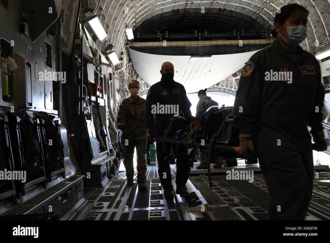 Maureen Hightower, Maj. De la Force aérienne des États-Unis, à gauche, infirmière de vol du 446e Escadron d'évacuation aéromédicale, Sgt. Sean Oliver, un 446e technicien d'évacuation aéromédicale AES, et Tech. Sgt. Jamie Salunga, un technicien d'évacuation aéromédical 446e AES, transporte une portée d'équipement d'urgence dans un C-17 Globemaster III le 2 mai 2021, sur la base conjointe Lewis-McChord, Washington. La civière de litière sert également de moyen de transrepérer l'équipement d'urgence ainsi que le personnel blessé en cas de crise. La mission principale de ces réservistes est de fournir des soins de survie en vol aux patients en réponse aux imprévus et Banque D'Images